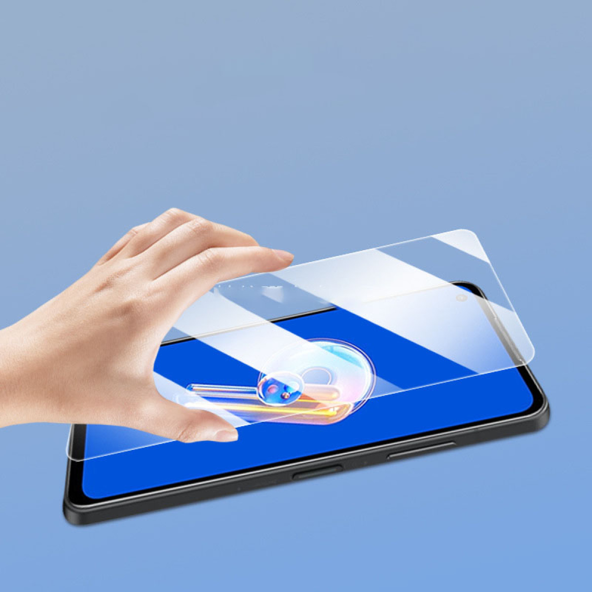 Una mano applica una protezione per lo schermo trasparente a un telefono con un display colorato.