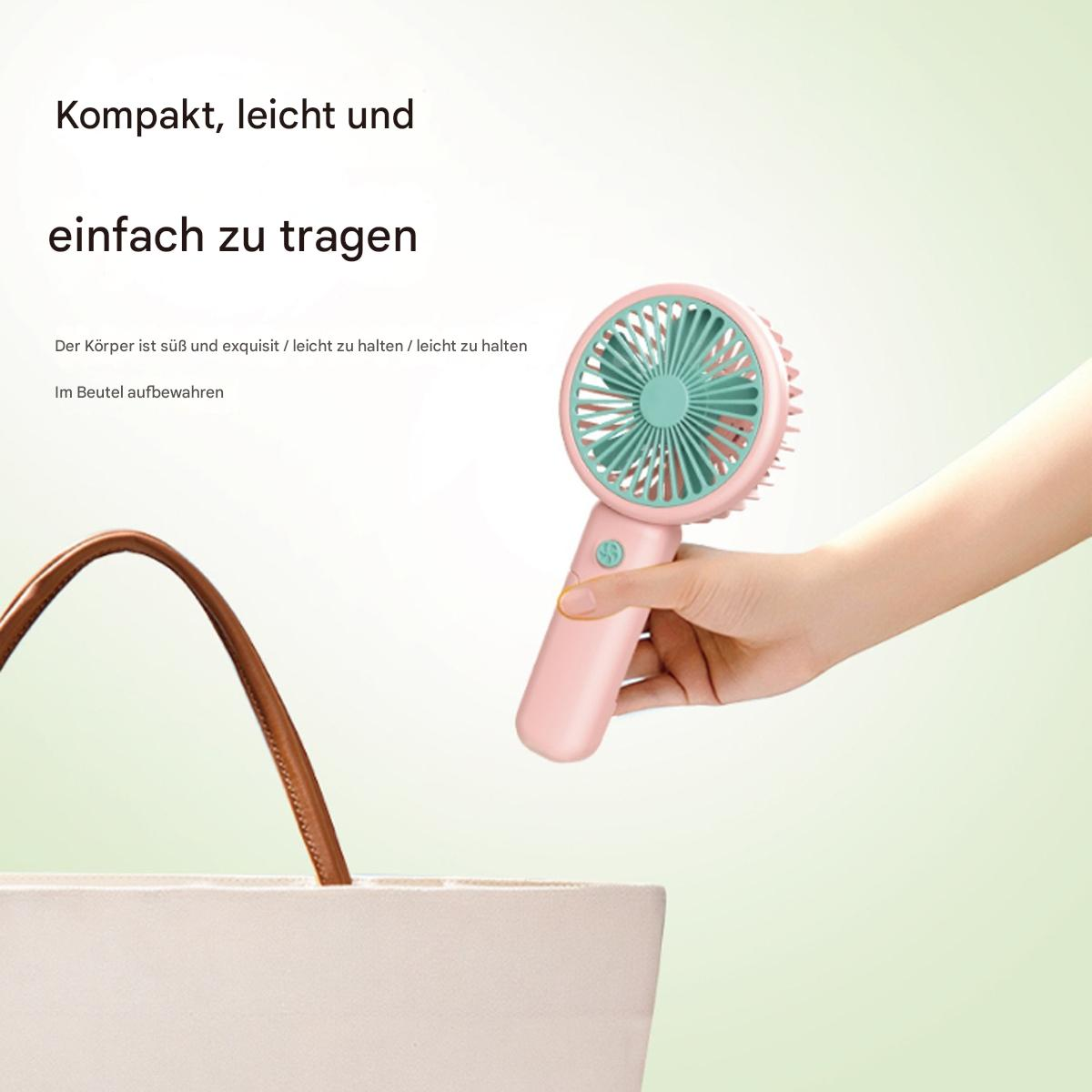 Eine Hand, die einen rosa Handventilator in der Nähe einer Tasche hält. Der Ventilator ist rosa und mintgrün.