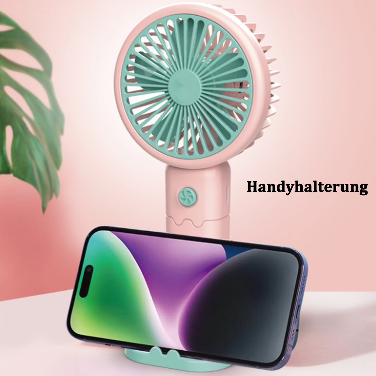 Rosa Handventilator mit einem Telefon in einem Ständer. Telefon zeigt ein farbenfrohes Bild. Text im Hintergrund: 'Handyhalterung'.