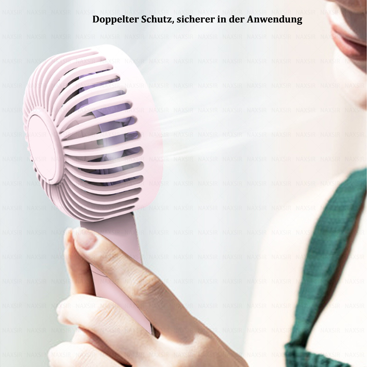 Eine Person hält einen rosa Handventilator, Luft bläst in Richtung eines Gesichts.