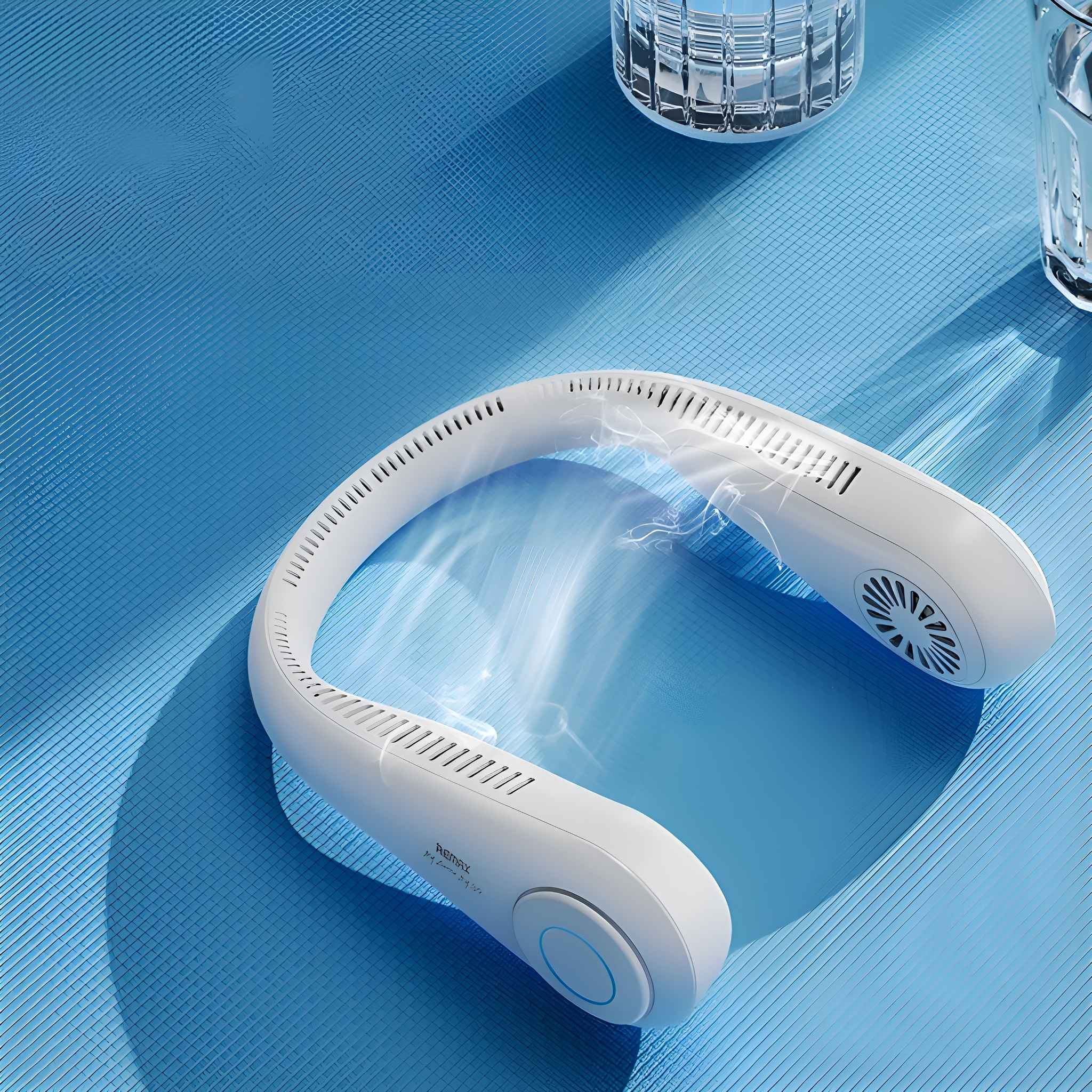 Weißer Nackenventilator auf blauer Oberfläche, mit zwei Wassergläsern.