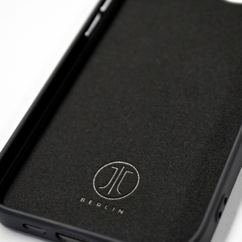 Gros plan de l'intérieur d'une coque de téléphone noire avec un logo et le mot 'Berlin'.