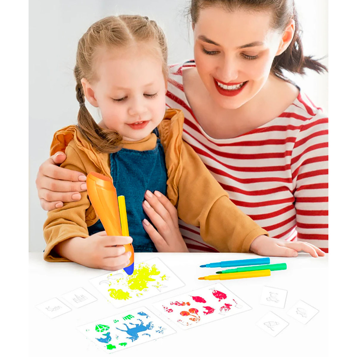 Donna e bambino che disegnano insieme. Penna 3D arancione con disegni in primo piano.
