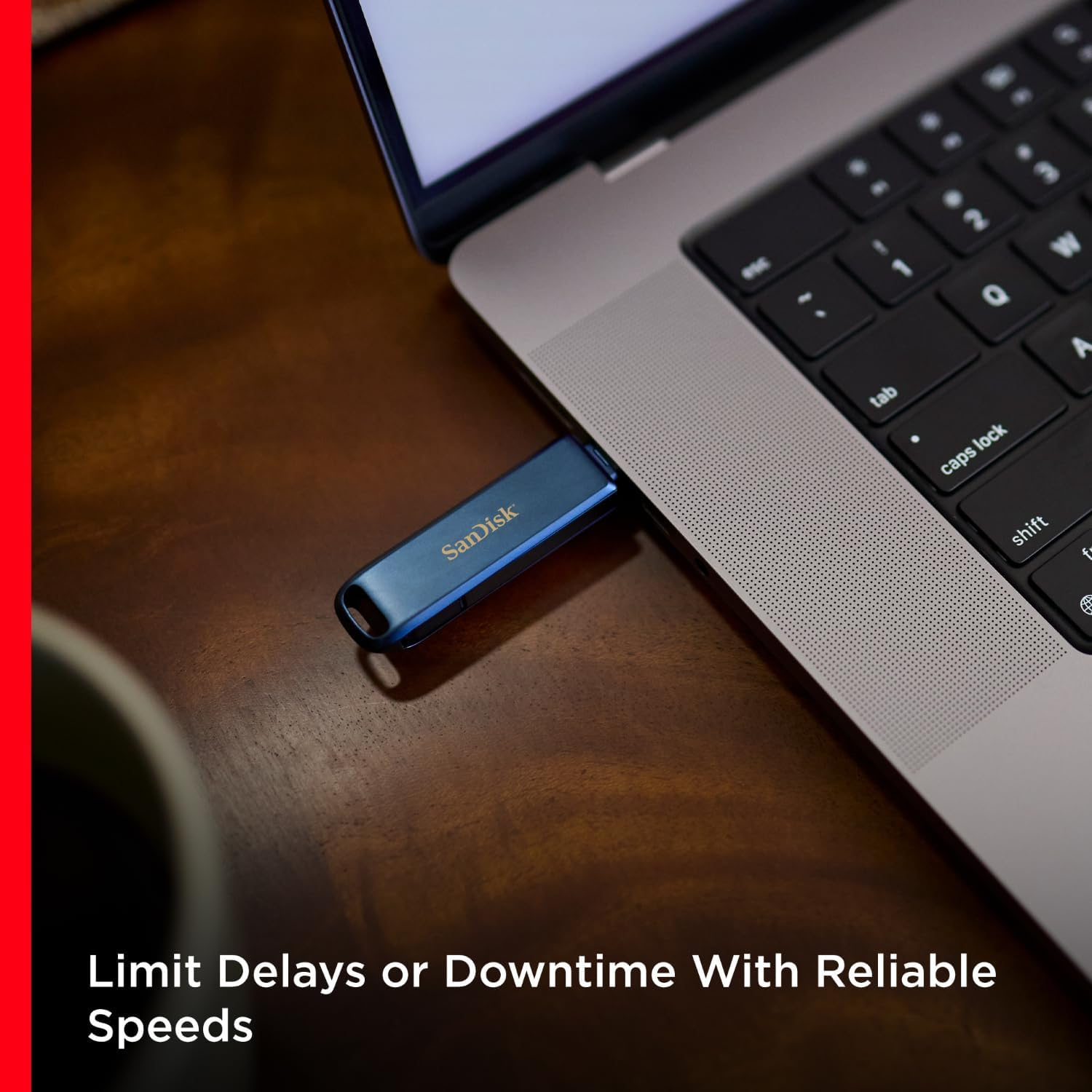 Ordinateur portable avec une clé USB insérée. La clé est bleue avec le logo Sandisk. L'écran est ouvert.