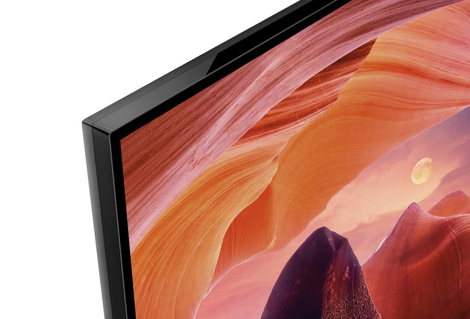 Zbliżenie krawędzi telewizora. Ekran wyświetla pustynny krajobraz z pełnią księżyca.