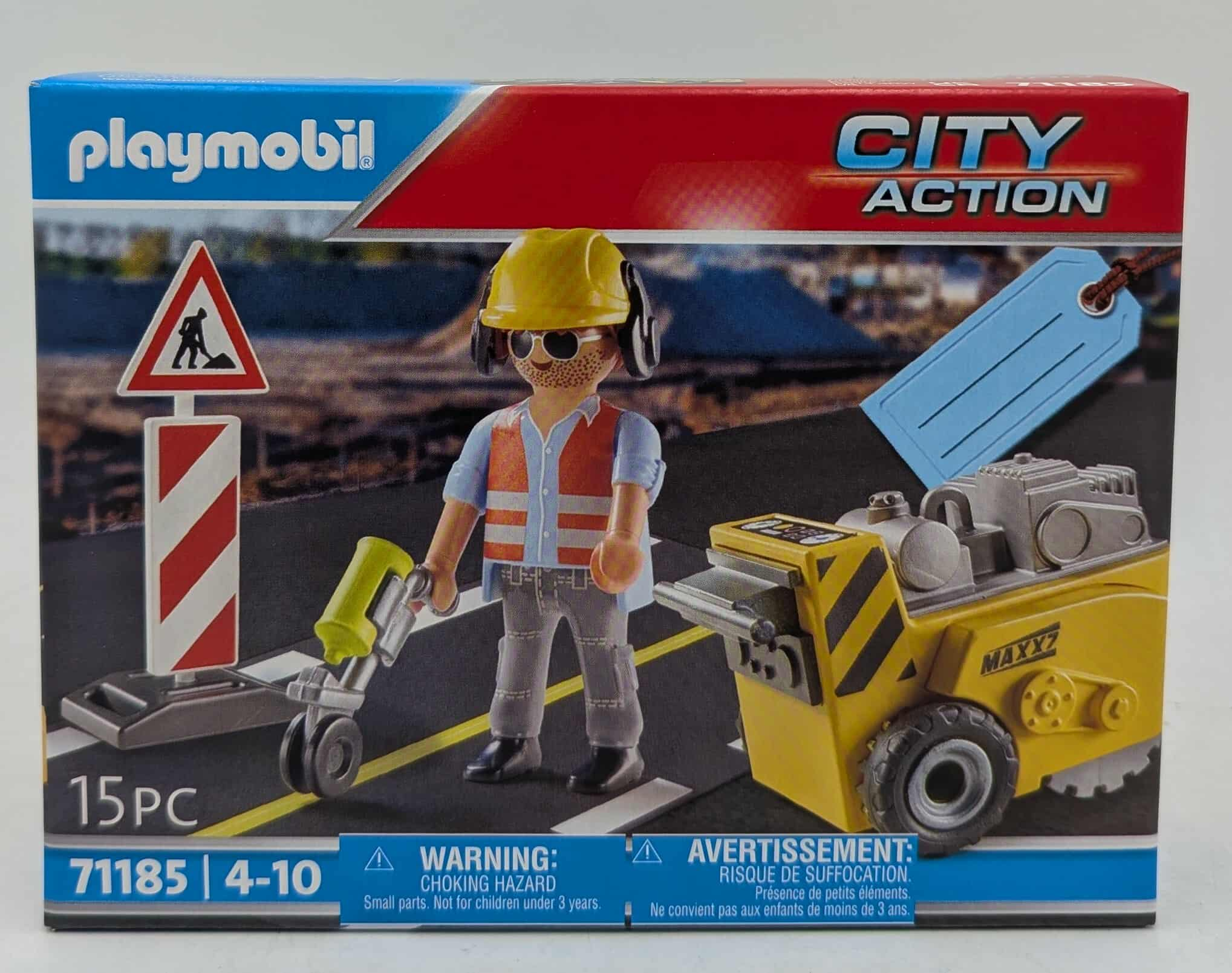 Playmobil-Konstruktionsspielzeugszene. Ein Arbeiter mit gelbem Helm steht in der Nähe eines Schildes und einer gelben Baumaschine.