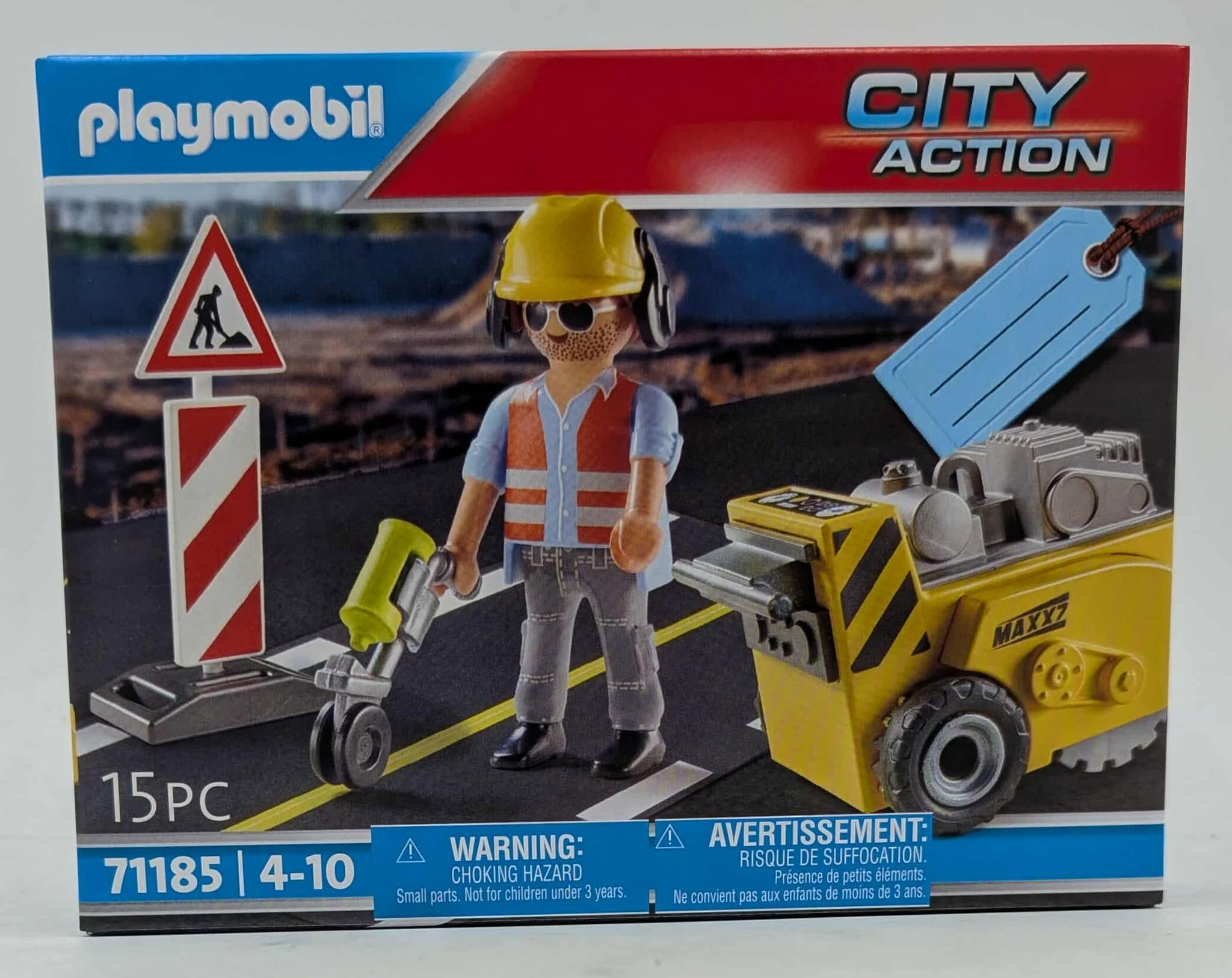 Playmobil-Spielzeug-Baustellenszene. Ein Arbeiter mit gelbem Helm steht neben einem Straßenschild und einer gelben Maschine.