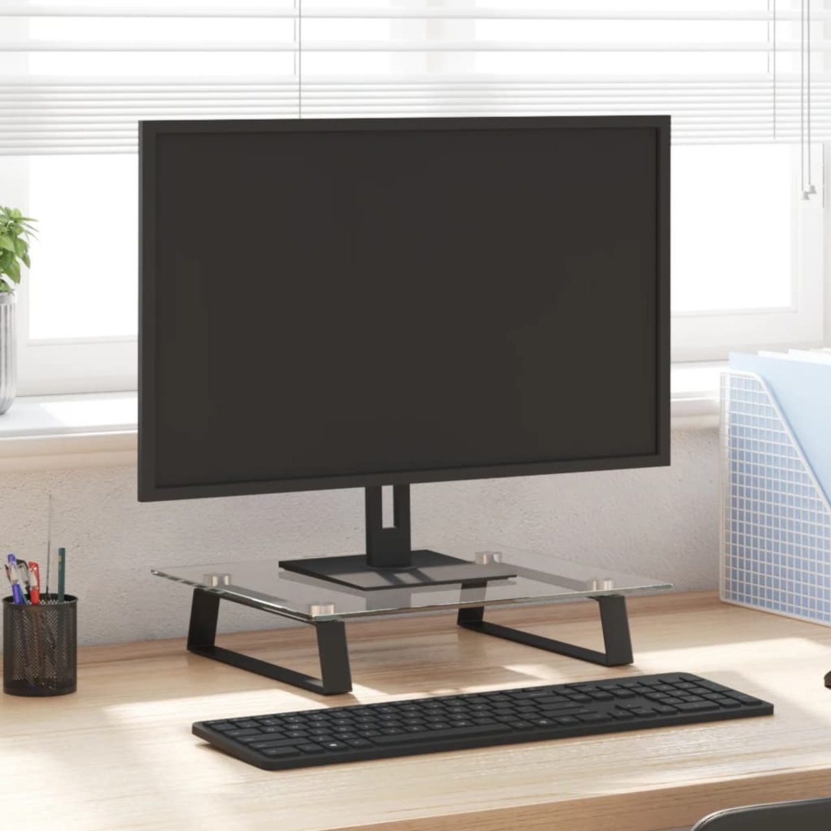 Schwarzer Monitor auf Glasständer, Tastatur und Schreibtisch.