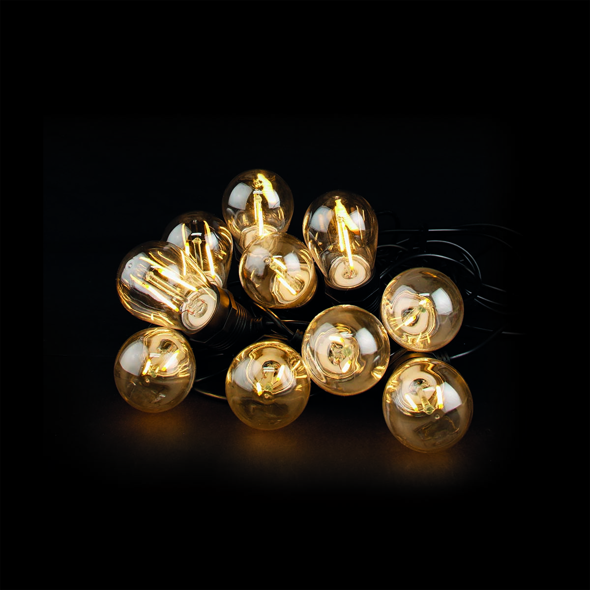 String lights with warm white bulbs are displayed. The background is black, the bulbs are glowing with a warm light.