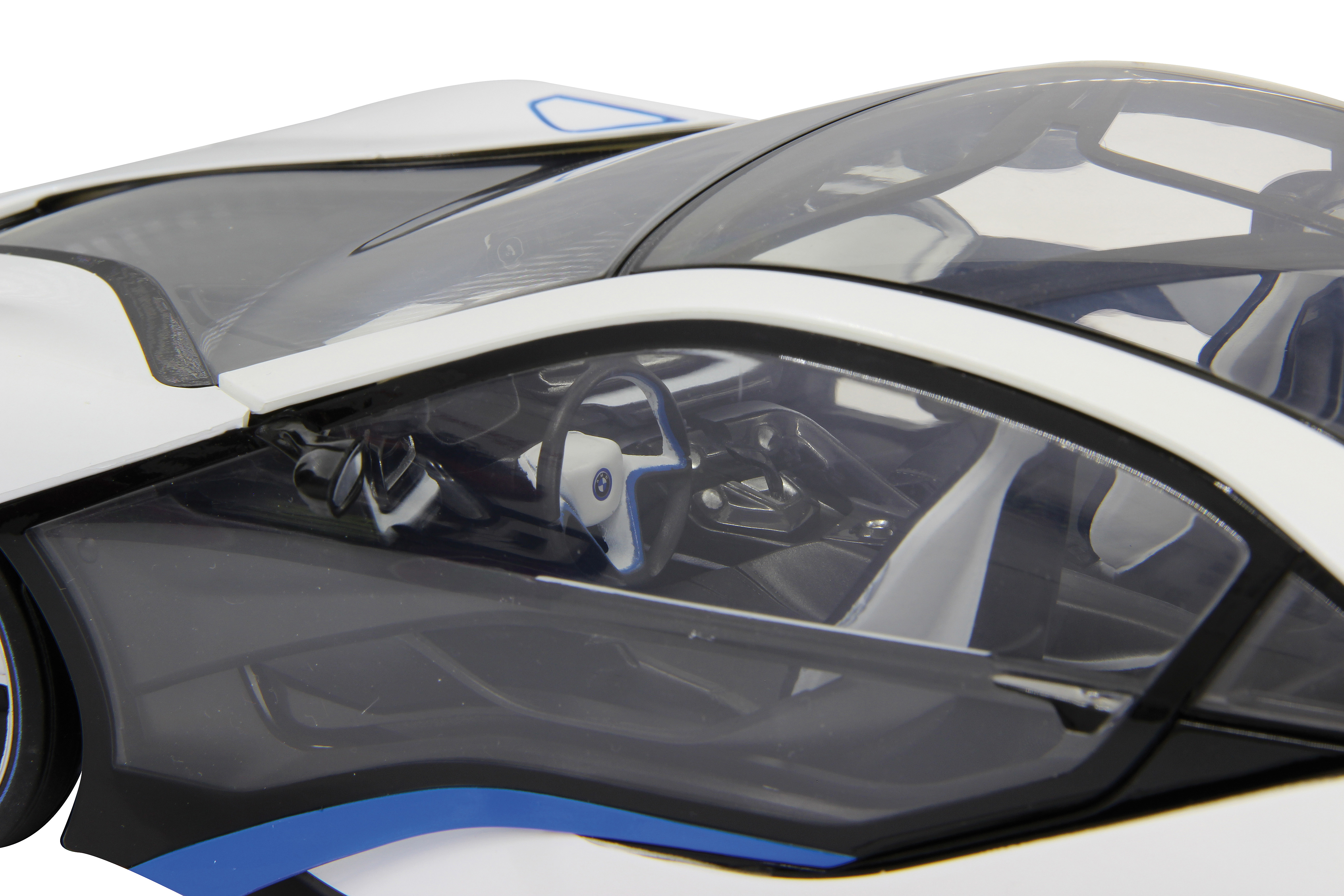 Widok wnętrza białego zabawkowego samochodu BMW i8, pokazujący kierownicę i deskę rozdzielczą.