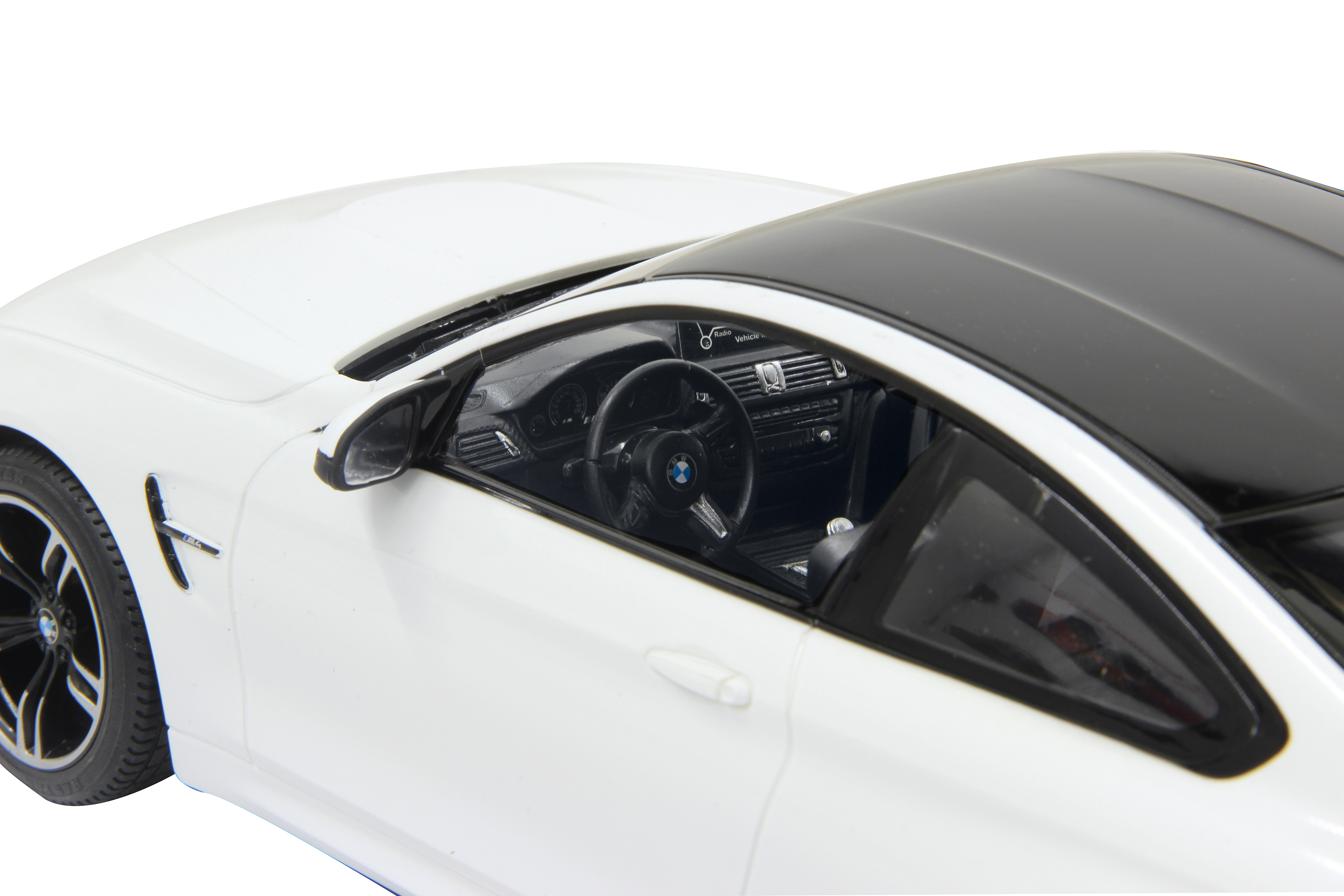 Close-up of a white BMW M4 Coupe interior, showing the dashboard and steering wheel.