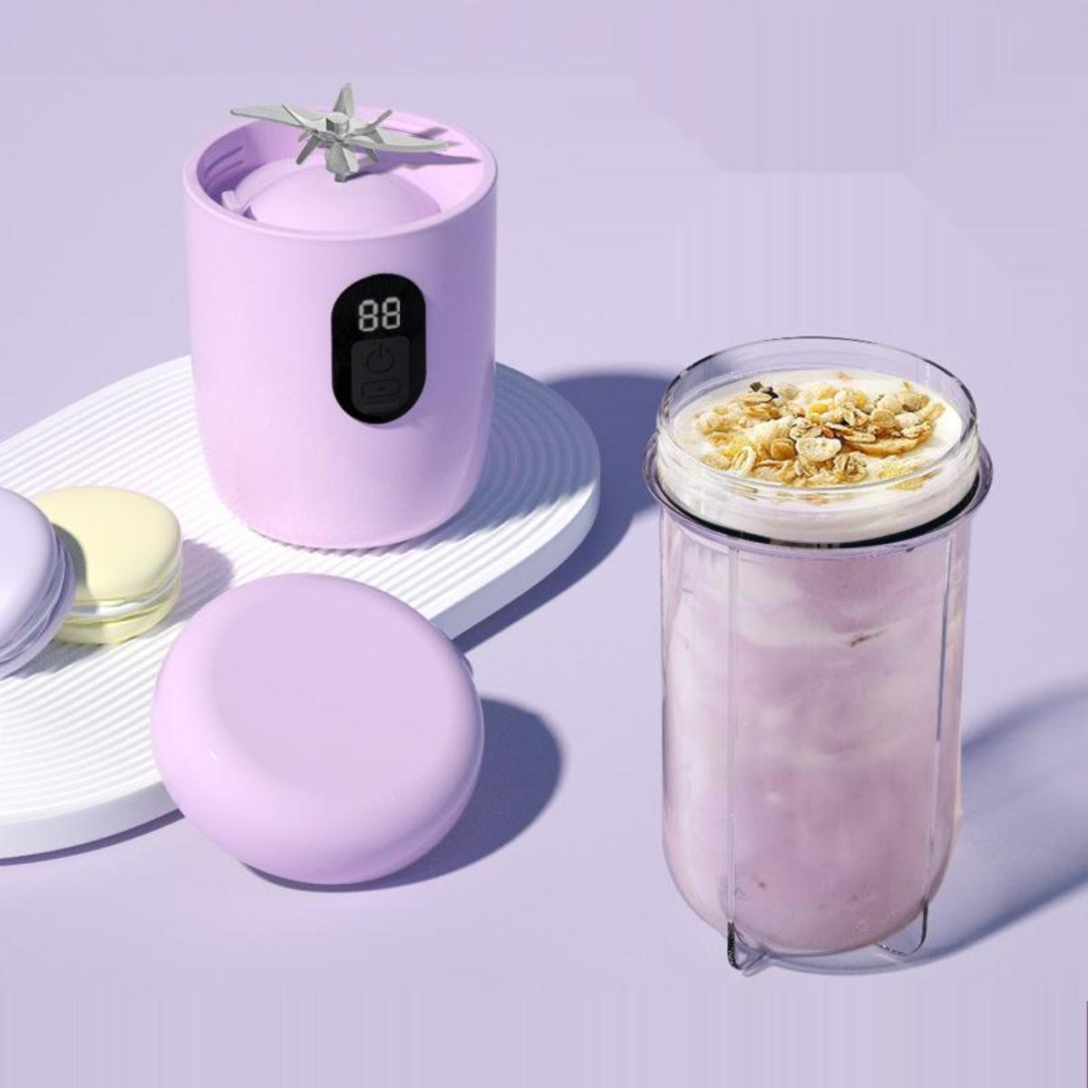 Ein lila Mixer mit einem transparenten Behälter, der einen Smoothie mit Müsli enthält.