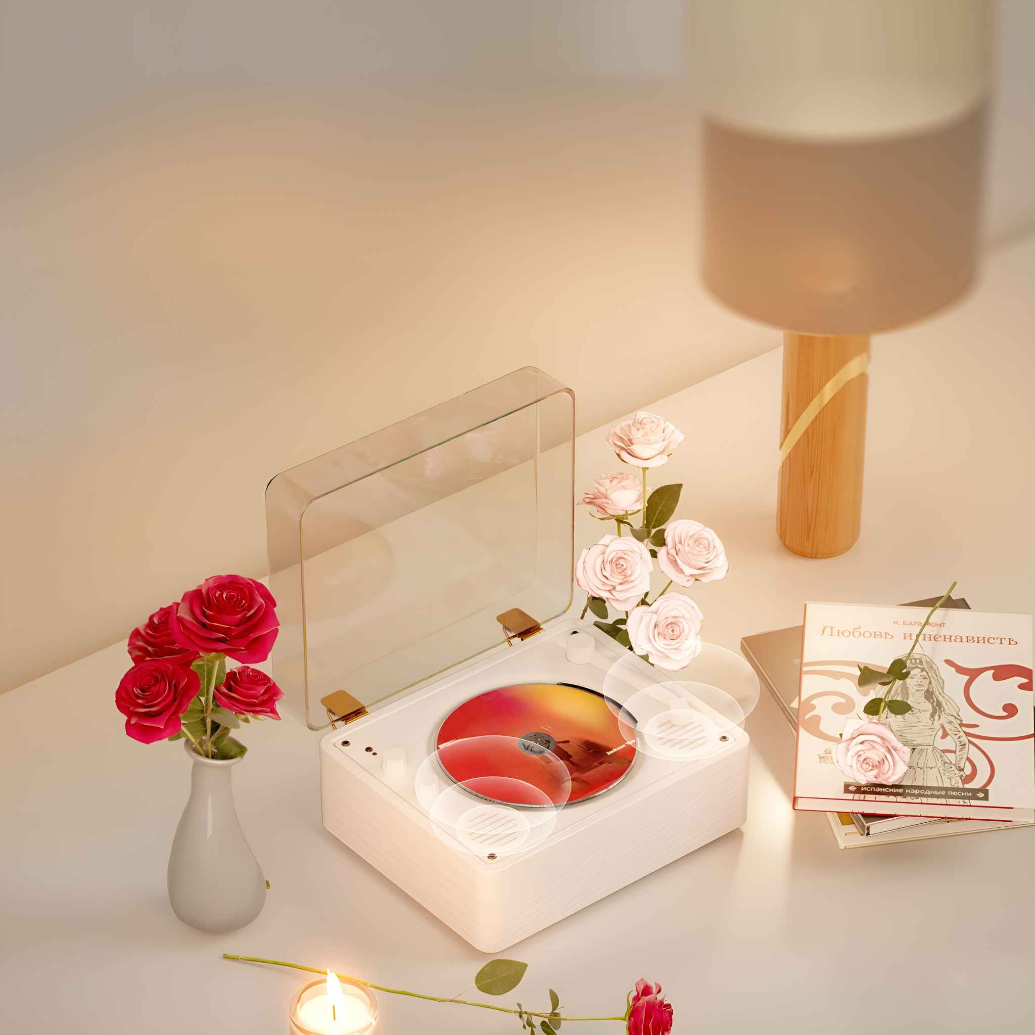 Weißer Plattenspieler, rote Scheibe, Rosen, Buch und Lampe auf Tisch.