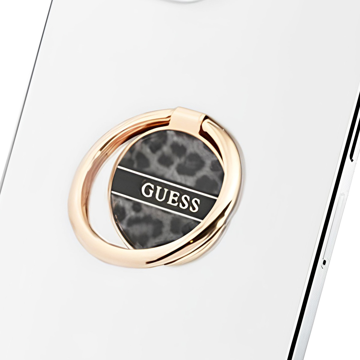 Anneau de téléphone doré avec motif léopard sur téléphone blanc.