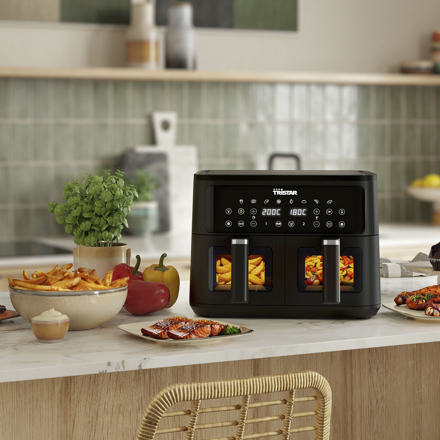 Black air fryer with food, fries, and peppers on a marble countertop.