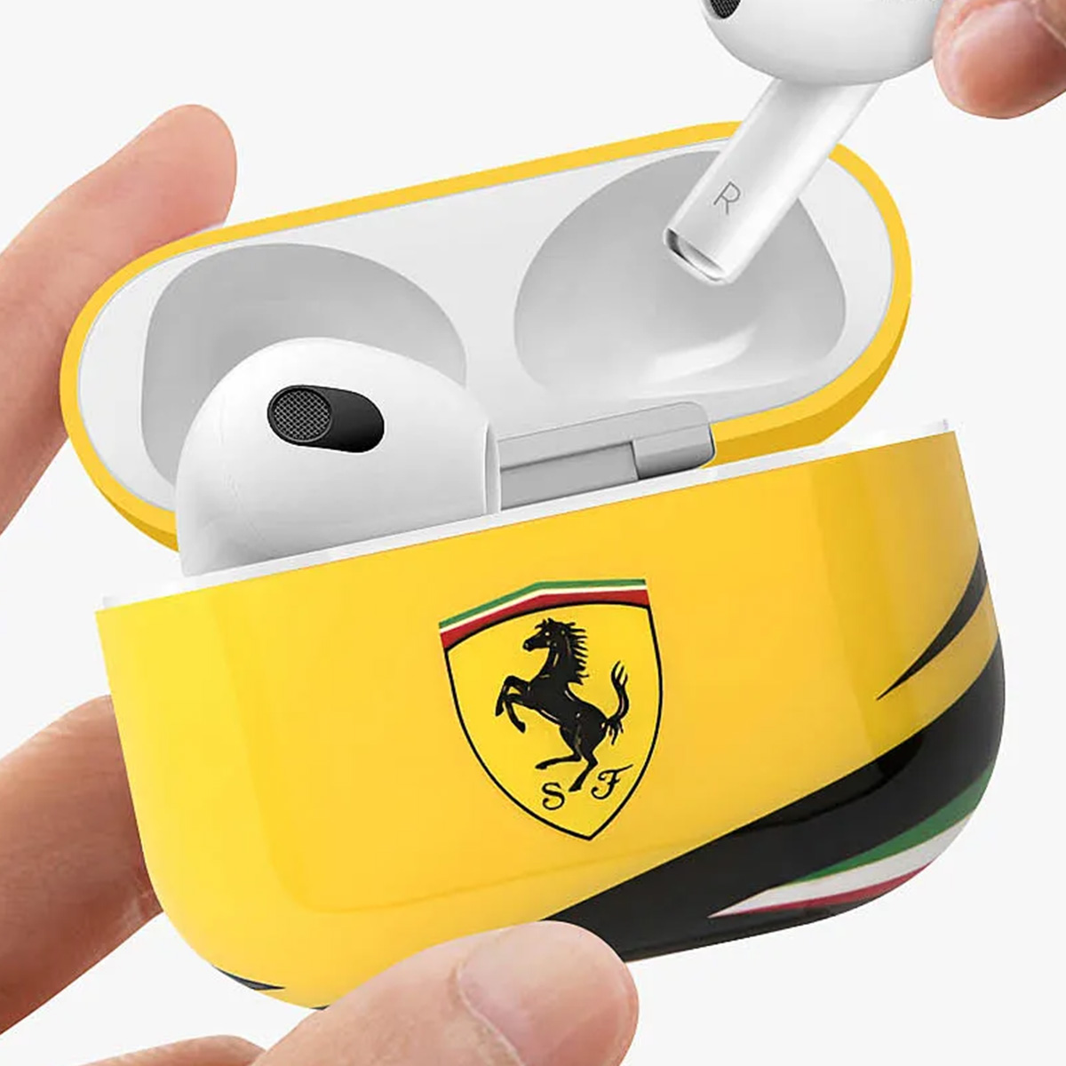 Auriculares en un estuche amarillo de la marca Ferrari, sostenidos en una mano. El estuche tiene rayas negras, verdes y blancas.
