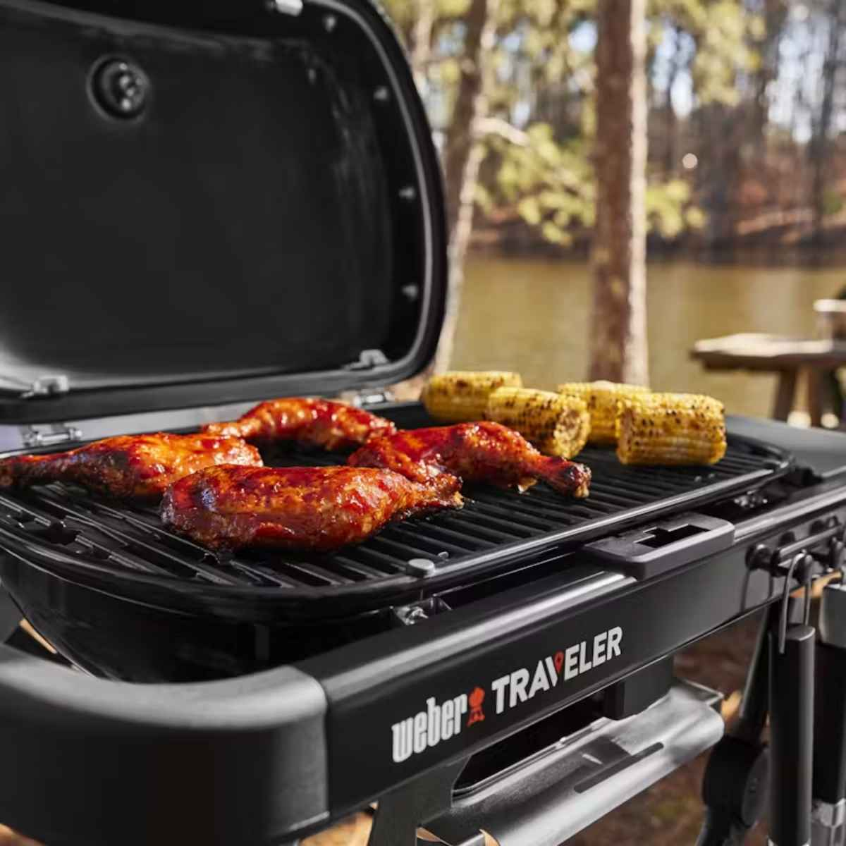 Grill Weber Traveler z grillowanym kurczakiem i kukurydzą, w plenerze.