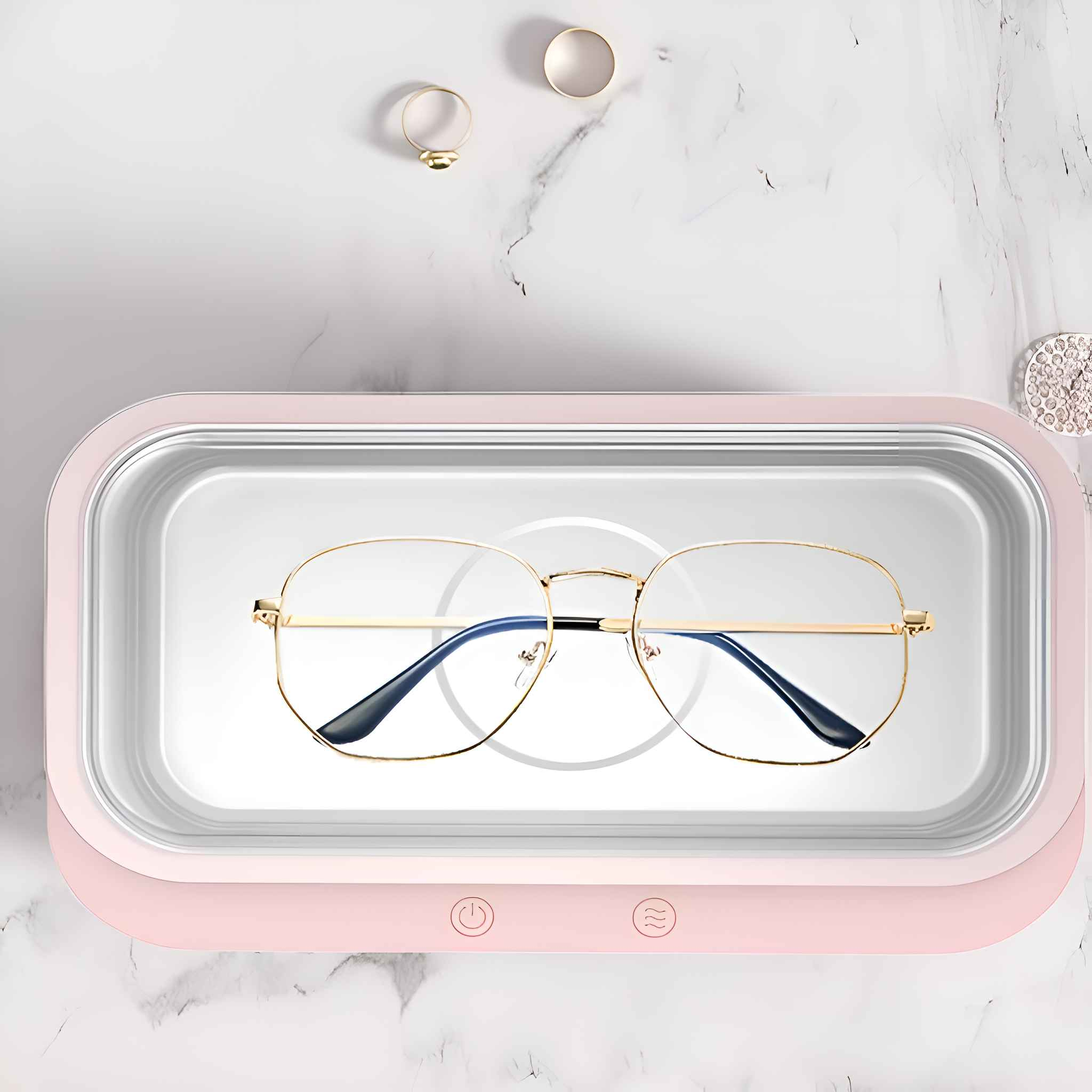 Ein rosa Ultraschallreiniger mit Brille im Inneren. Die Brille befindet sich in der Mitte des Reinigers.