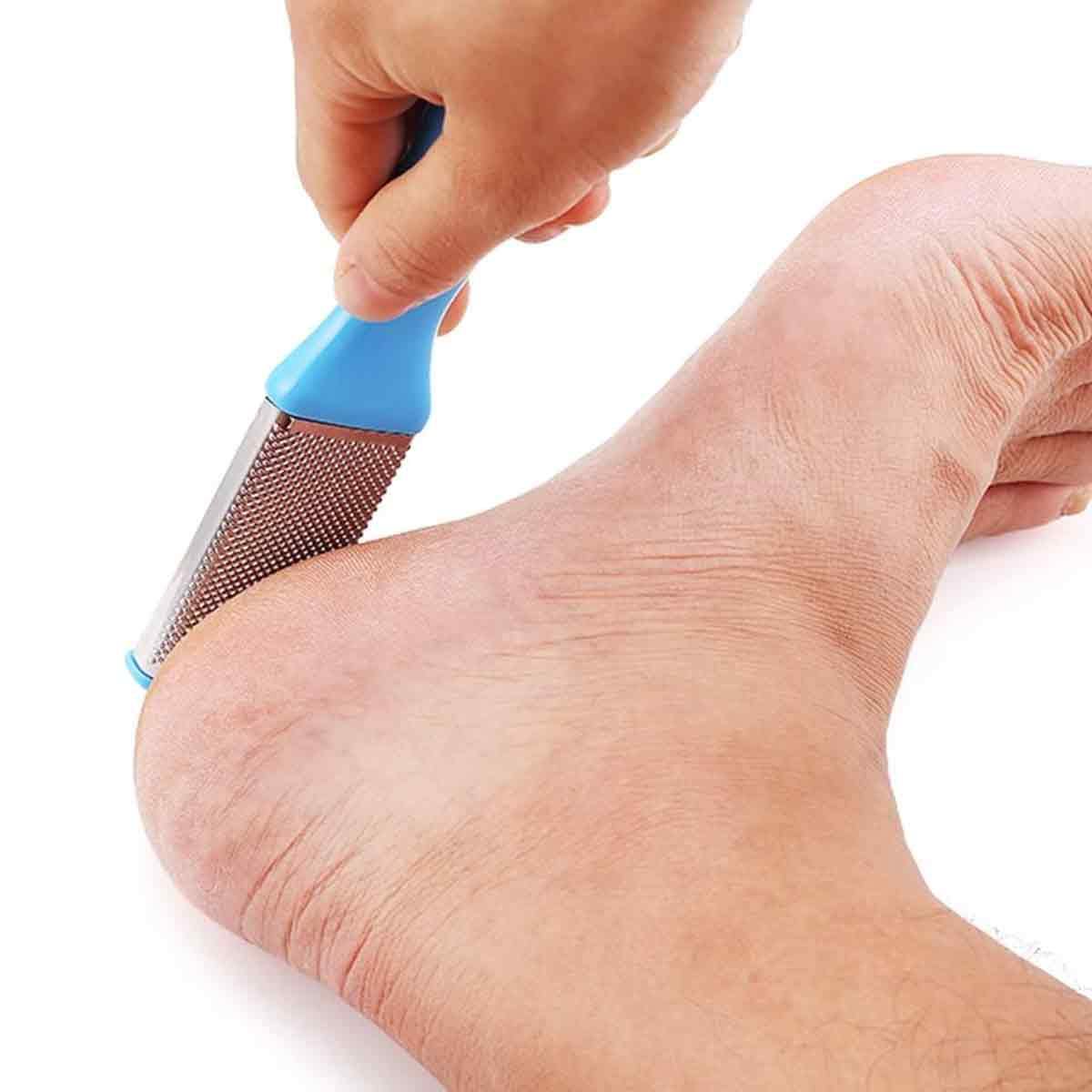Die Hand einer Person hält eine blaue Fußfeile, um einen Fuß zu schleifen. Der Fuß ist rechts.