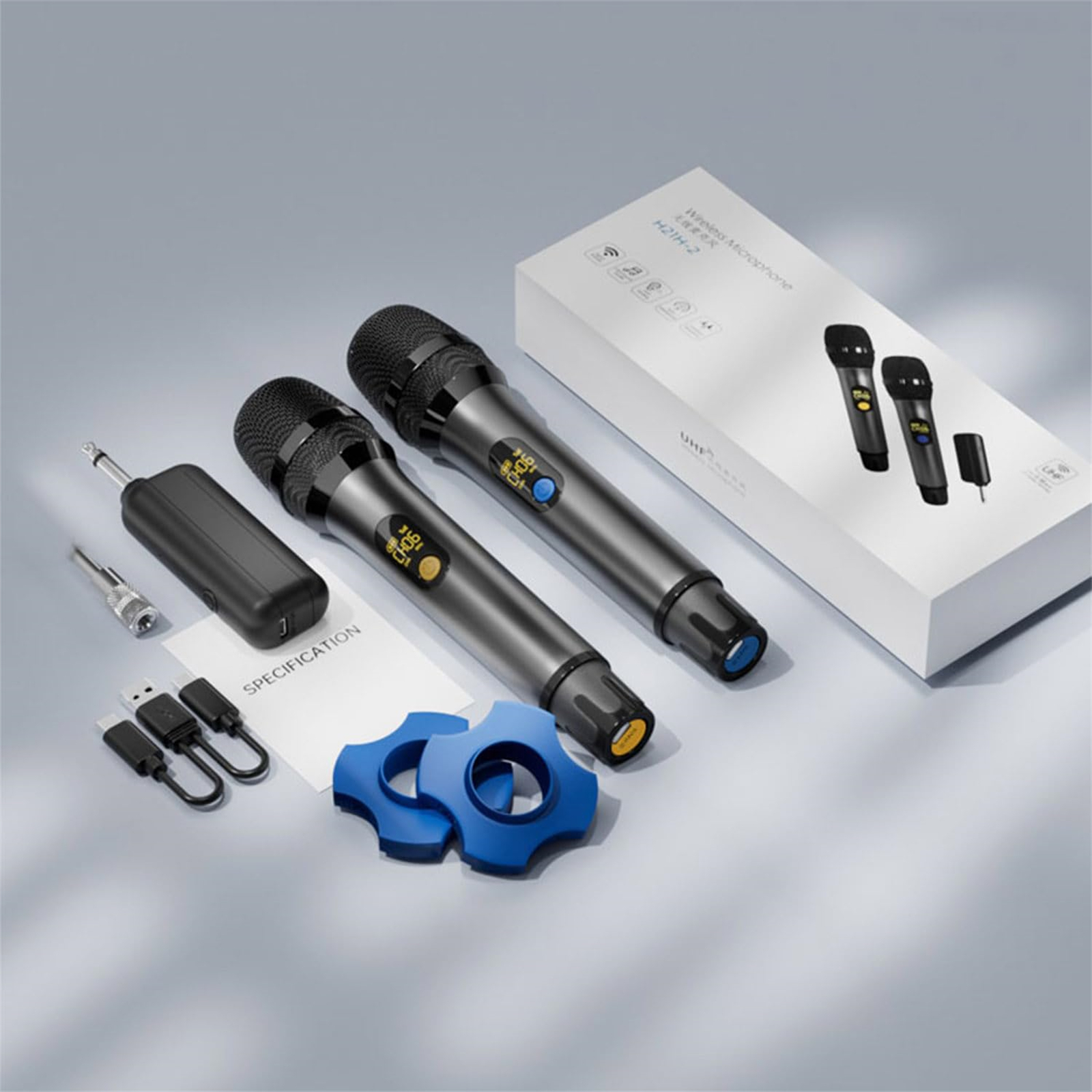 Zwei drahtlose Mikrofone, ein Empfänger, Kabel und eine Schachtel werden gezeigt.