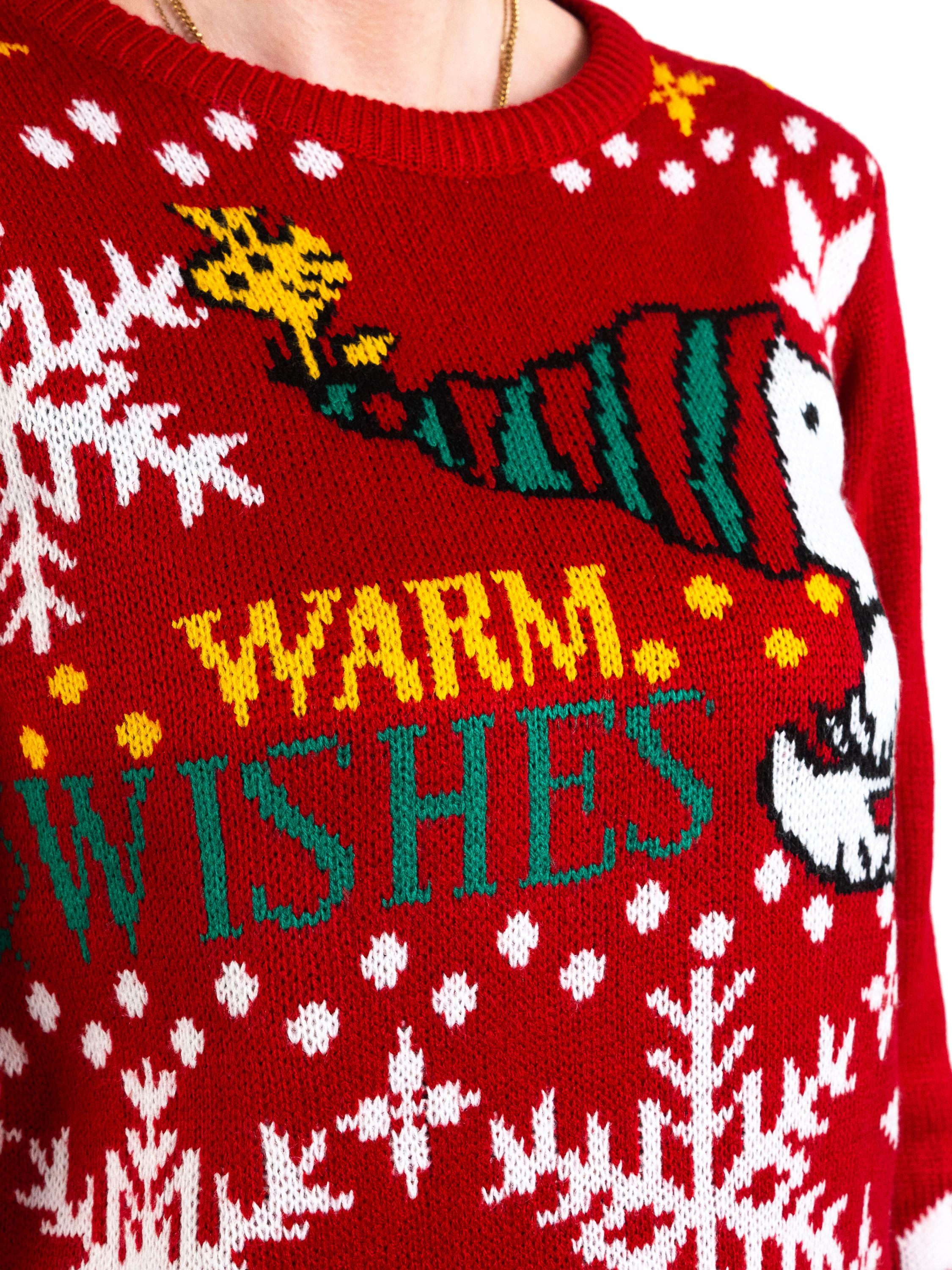 Roter Weihnachtspullover mit Snoopy und den Worten "WARM WISHES". Weiße Schneeflocken und gelbe Punkte sind ebenfalls sichtbar.