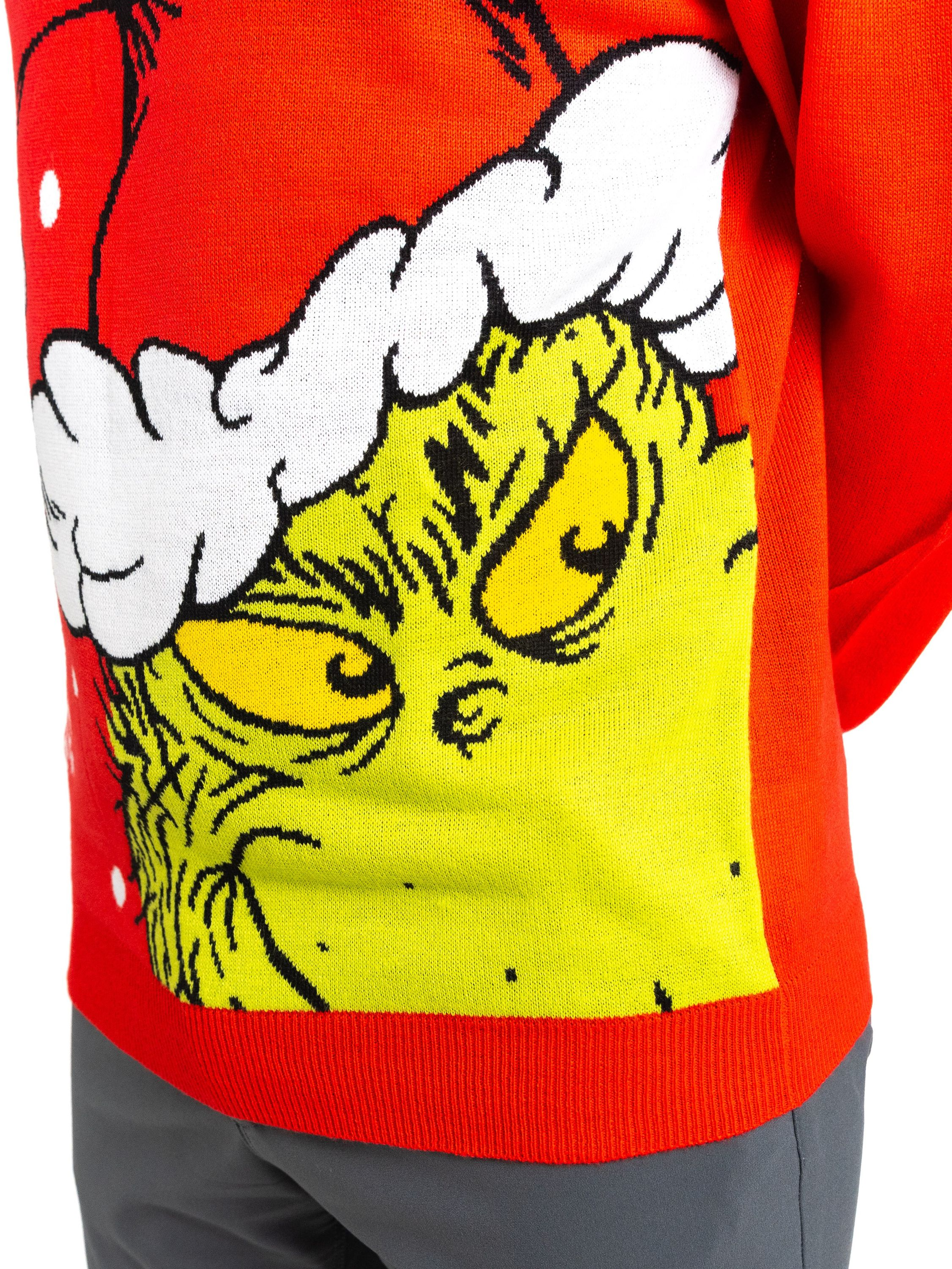 Roter Weihnachtspullover mit Grinch-Gesicht. Der Grinch ist grün mit gelben Augen und weißem Weihnachtsmannhut.