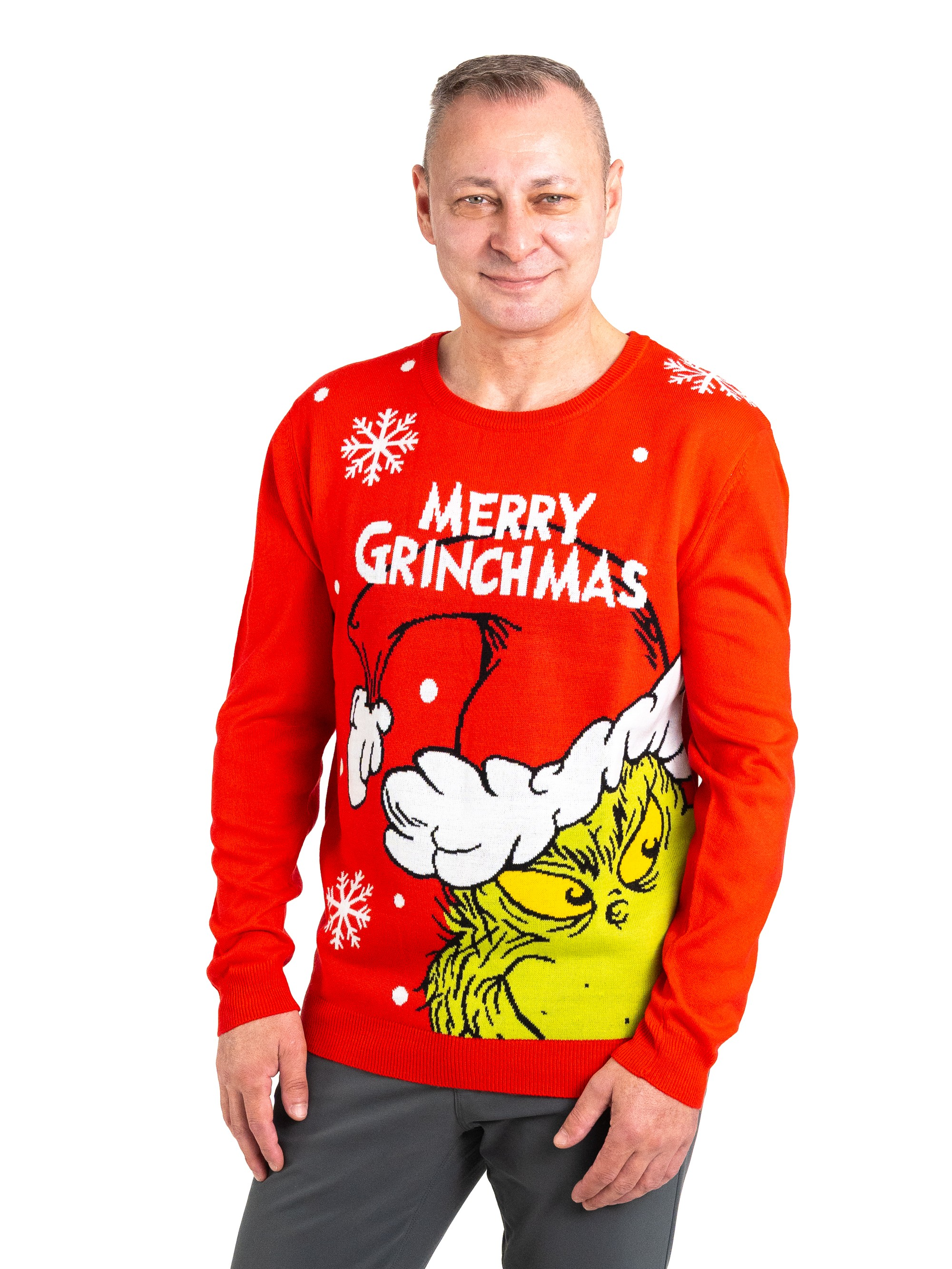 Ein Mann trägt einen roten Weihnachtspullover mit dem Grinch. Er lächelt, und der Hintergrund ist weiß.