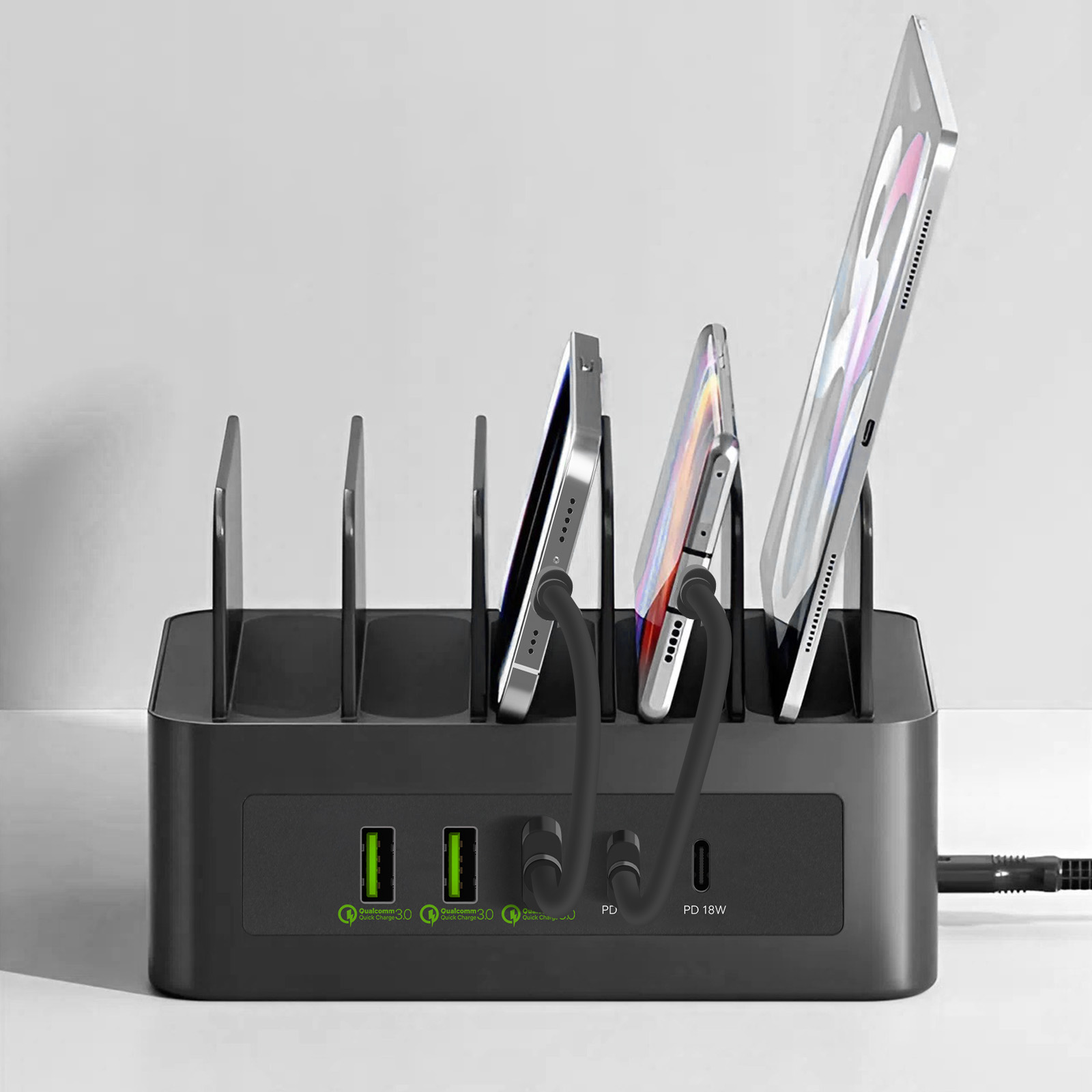 Abbildung einer Ladestation mit mehreren Geräten wie Handys und Tablets, die organisiert aufgeladen werden.