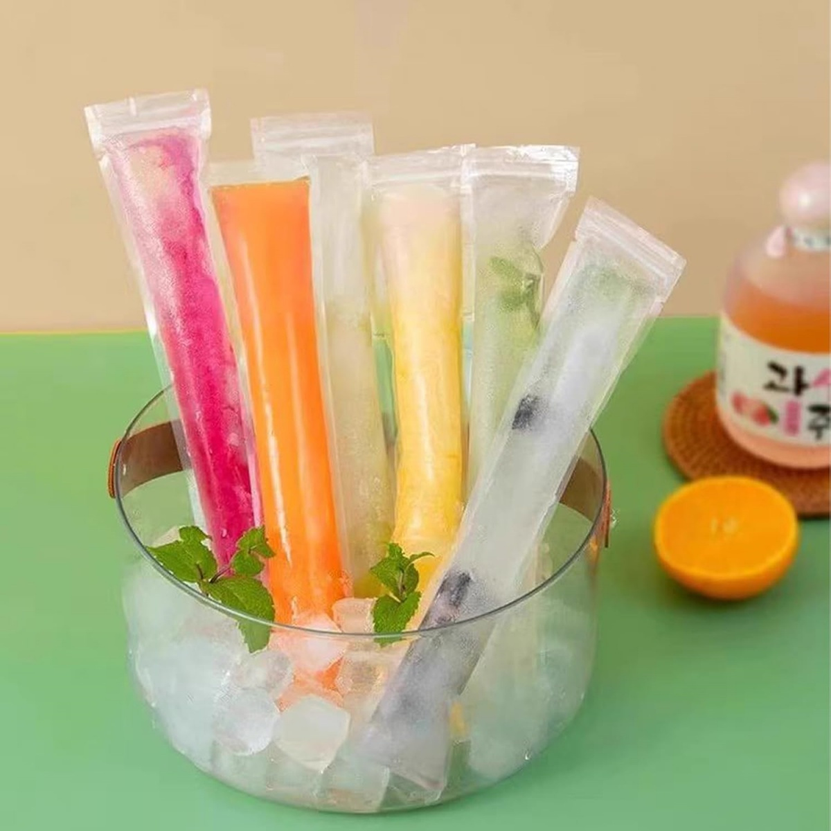 Bunte Eis am Stiel in einer Glasschale mit Eiswürfeln. Die Eis am Stiel sind in verschiedenen Farben.