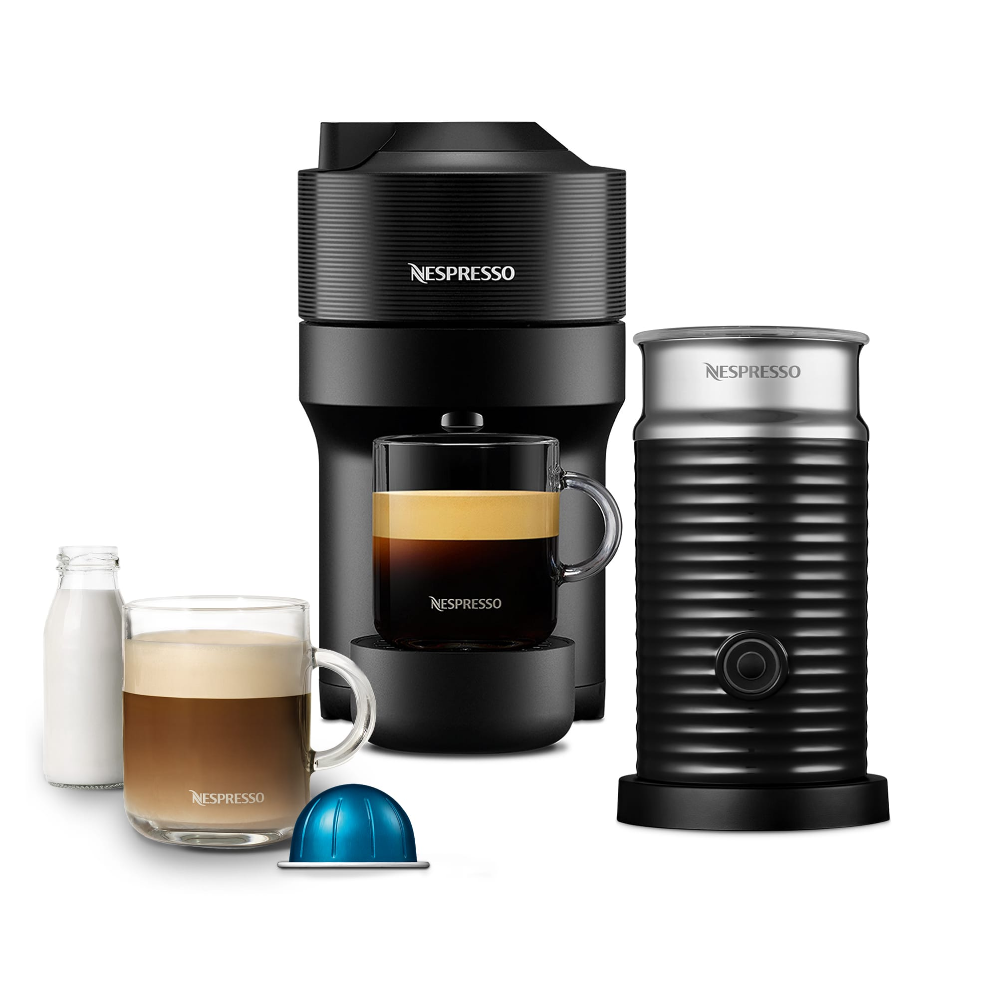 Schwarze Nespresso-Maschine, Milchaufschäumer, Kaffeetasse und Milchflasche. Eine blaue Kaffeekapsel liegt auf der Oberfläche.