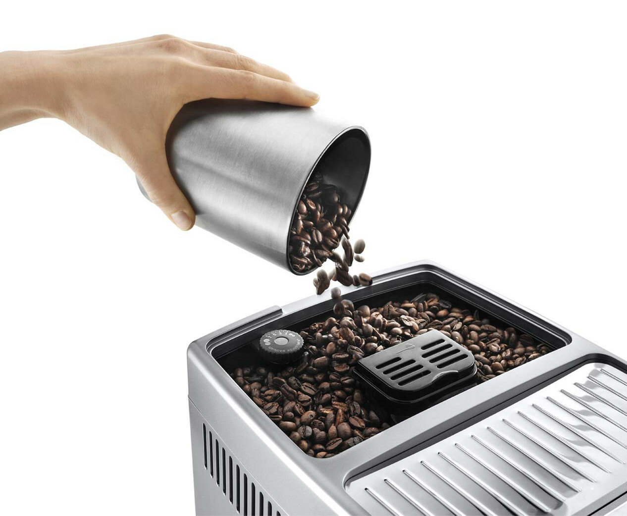 Ręka wsypująca ziarna kawy do pojemnika z ziarnami kawy, część ekspresu do kawy.