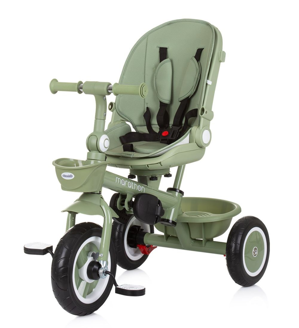 Ein grünes Dreirad mit Sitz und Pedalen, mit einem Korb vorne, vor weißem Hintergrund.