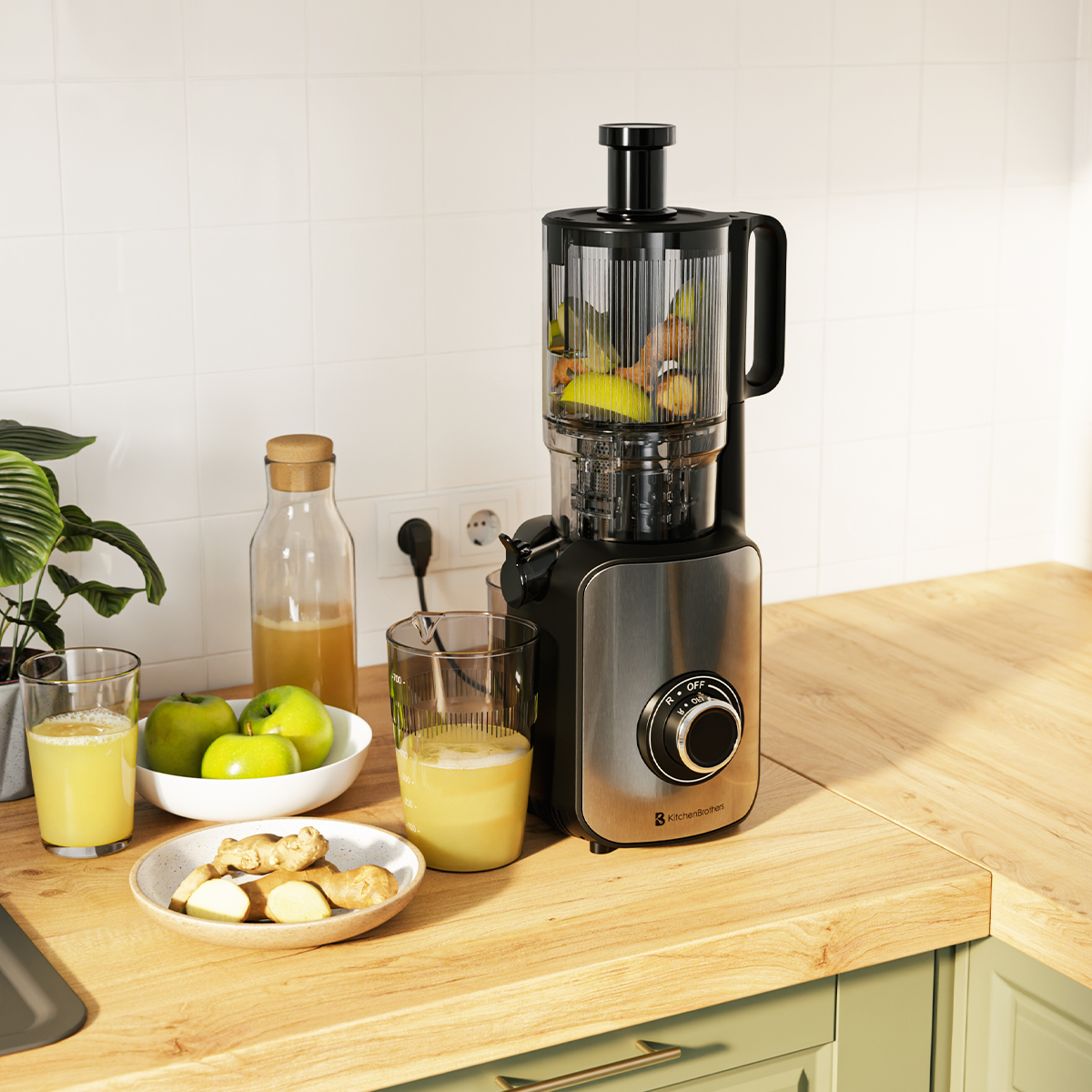 Un extracteur de jus sur un comptoir en bois avec des fruits et des verres de jus. Pommes, gingembre et une bouteille aussi.