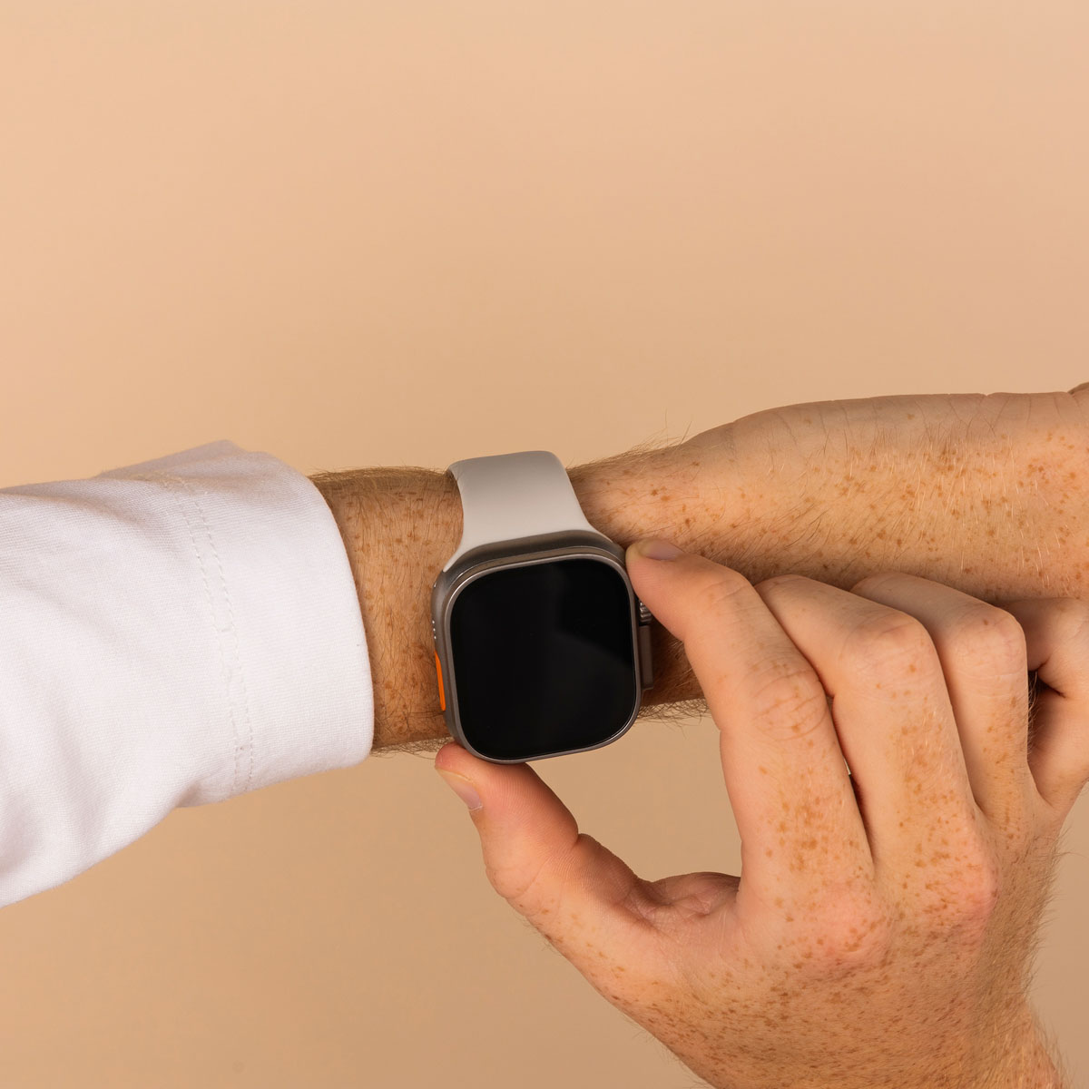 Man's wrist with a watch. He is touching the watch screen with his finger.