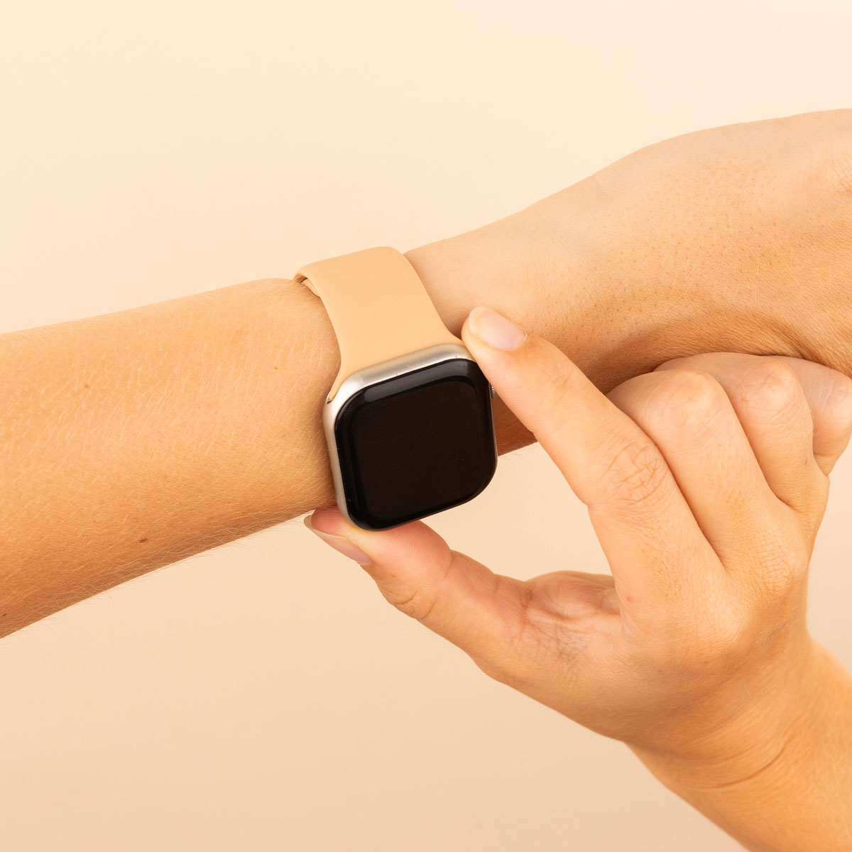 A wrist with a watch. A finger is touching the watch screen.