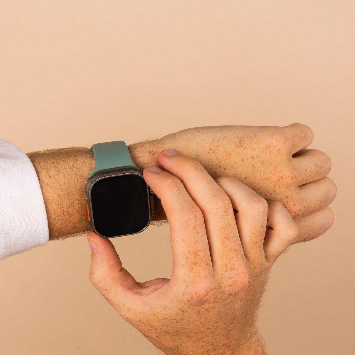 Man's wrist with a watch. He is touching the watch screen with his finger.
