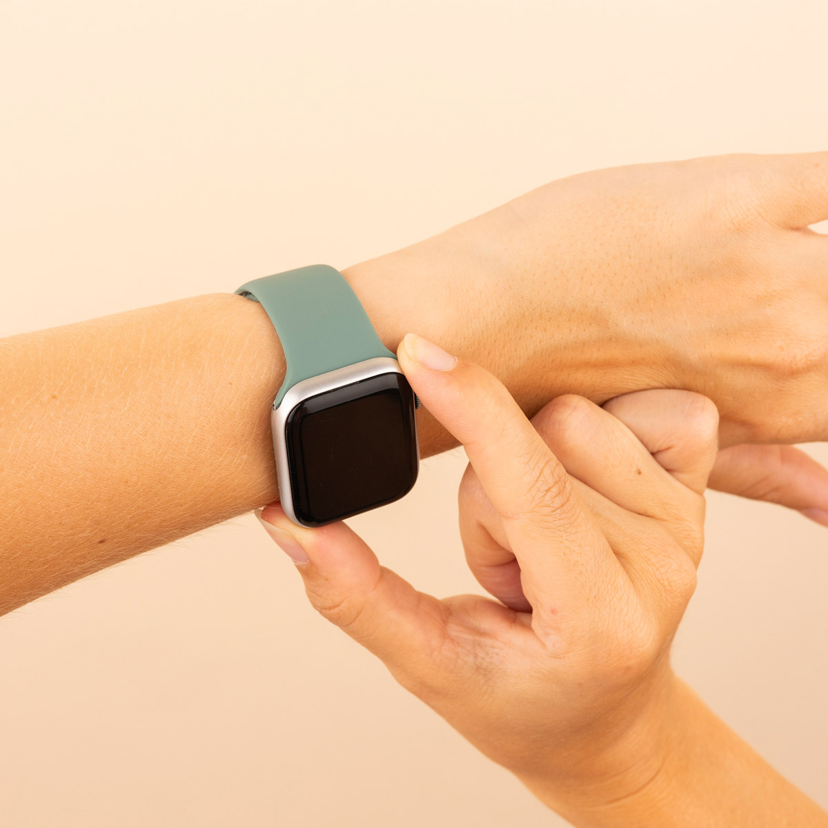 A wrist with an Apple Watch. The watch is silver, black screen, and a teal colored band.