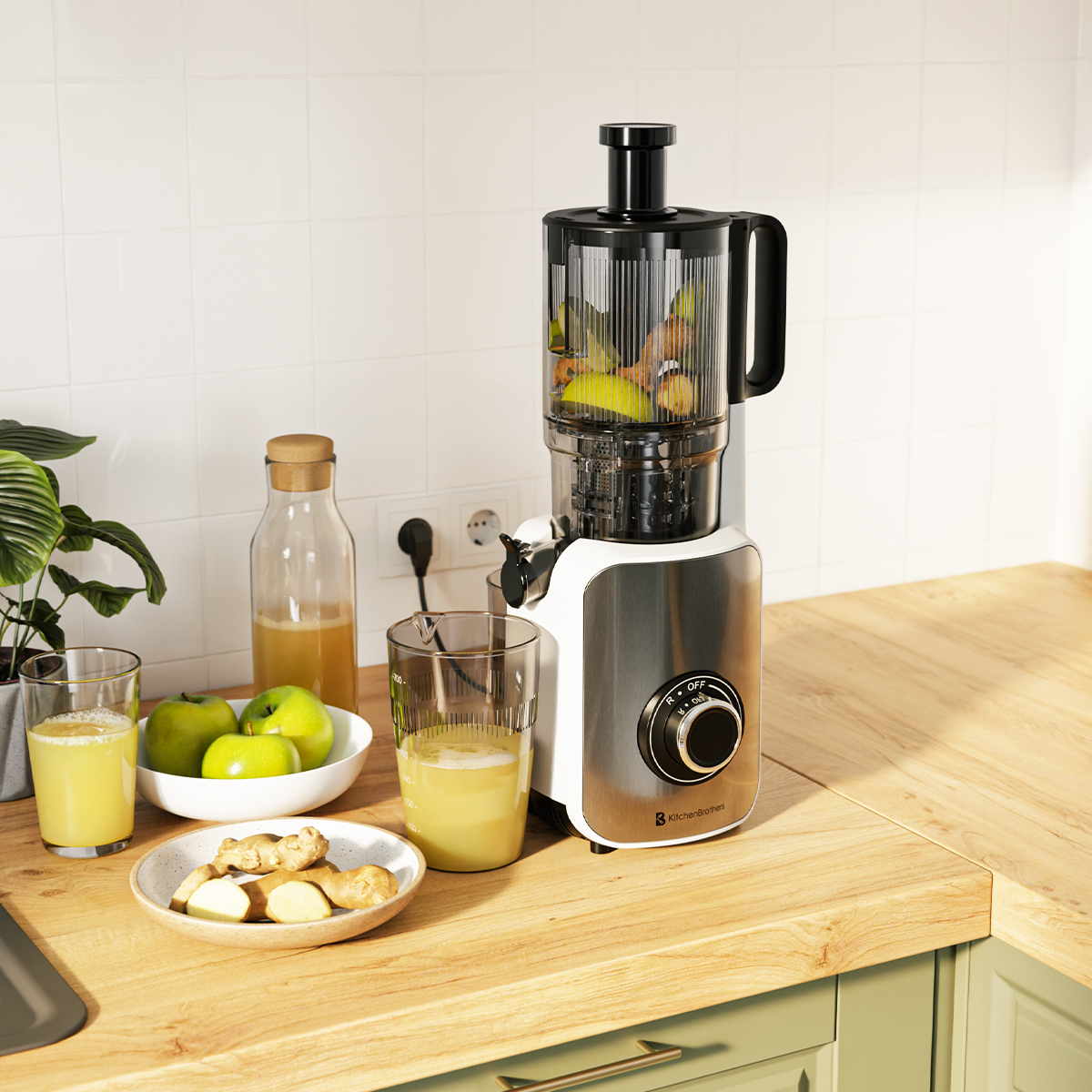 Een juicer met fruit en een glas sap op een houten aanrecht met keukenartikelen.