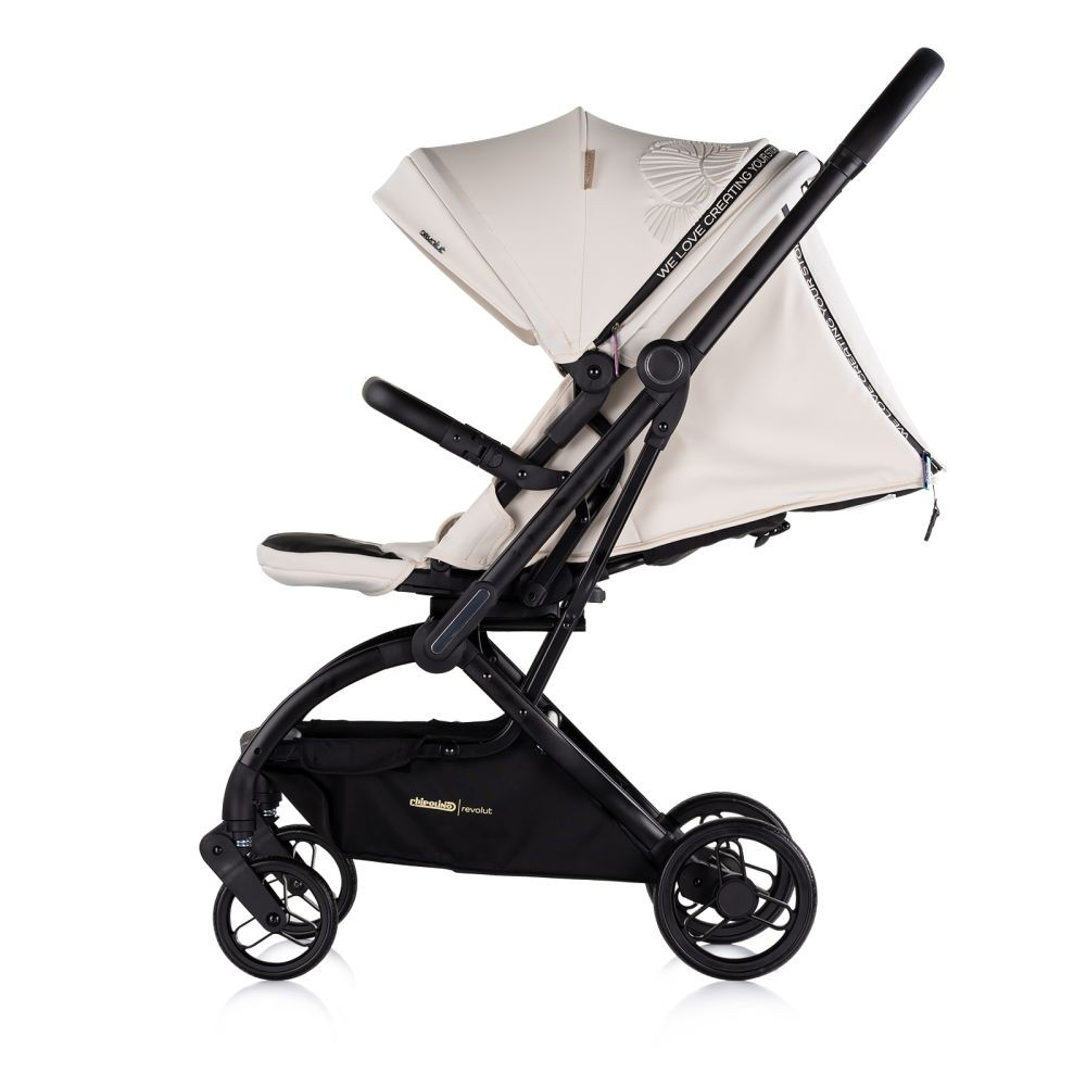 Beiger Kinderwagen im Profil mit schwarzem Rahmen. Die Haube ist oben. Der Kinderwagen hat einen schwarzen Korb.