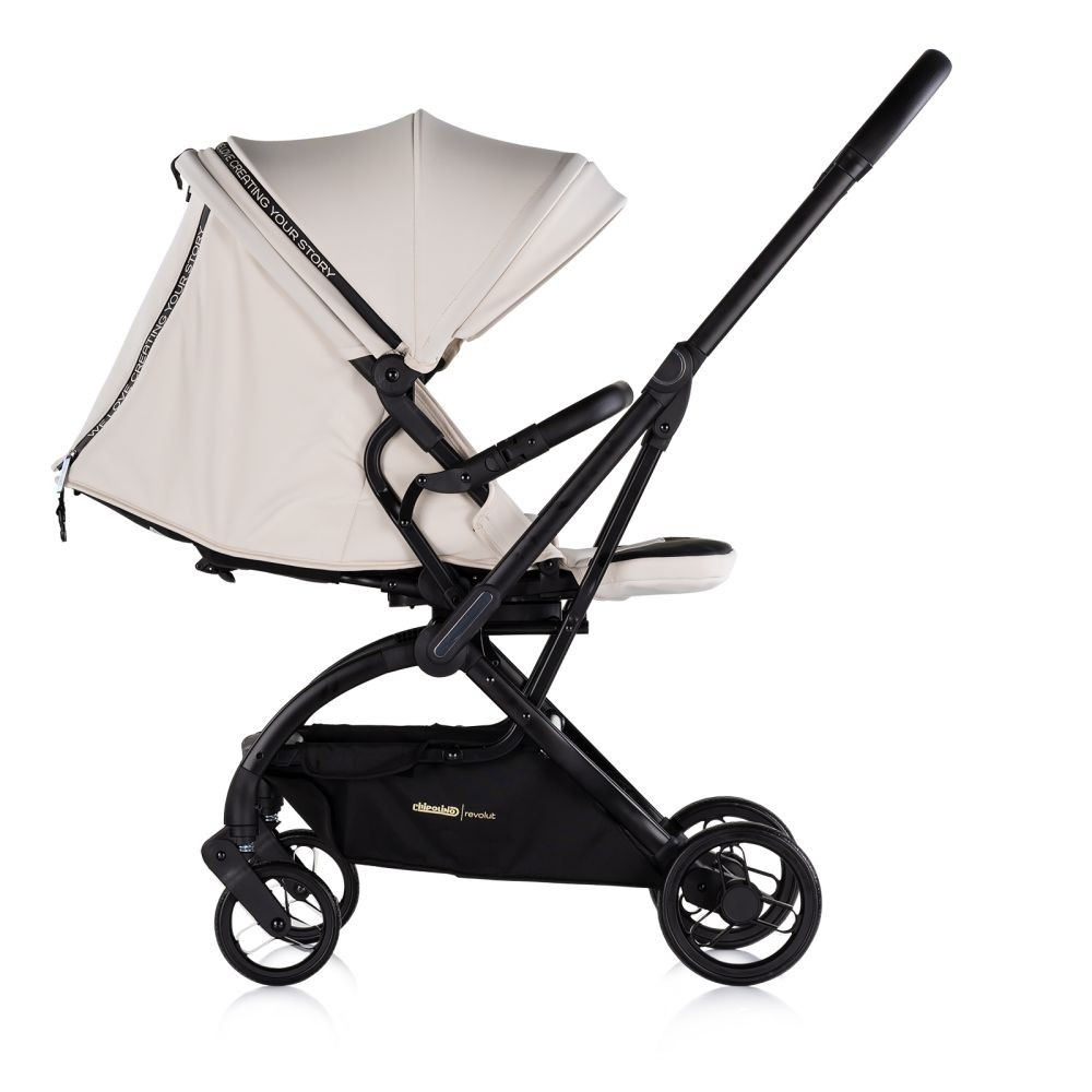 Ein hellbeiger Kinderwagen mit schwarzem Rahmen. Er hat ein Verdeck, einen Sitz und einen Aufbewahrungskorb.