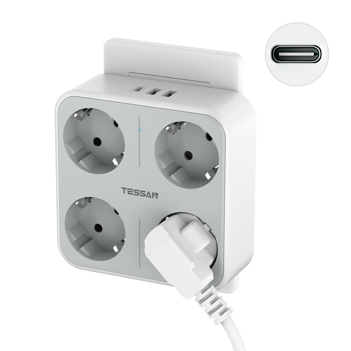 Una regleta blanca con cuatro enchufes y puertos USB. Un enchufe está insertado en un enchufe. El texto 'TESSAN'.
