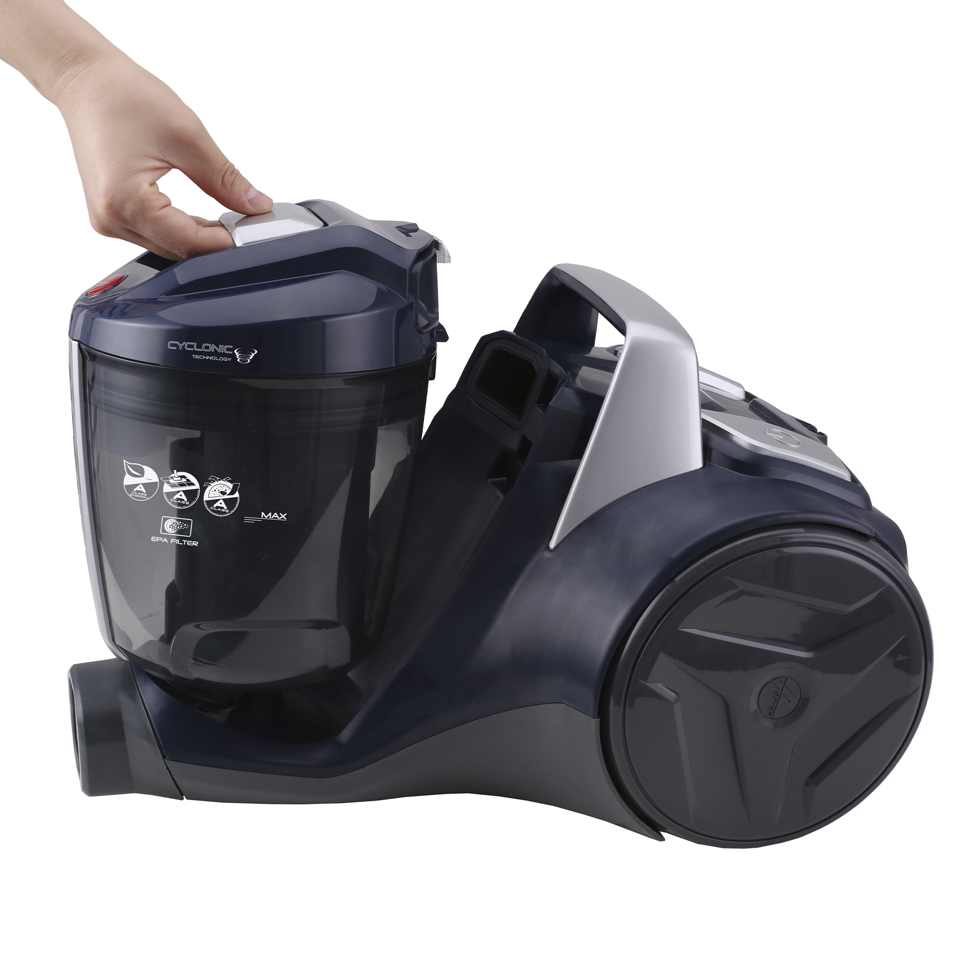 Ręka otwierająca komorę na kurz w czarno-srebrnym odkurzaczu.