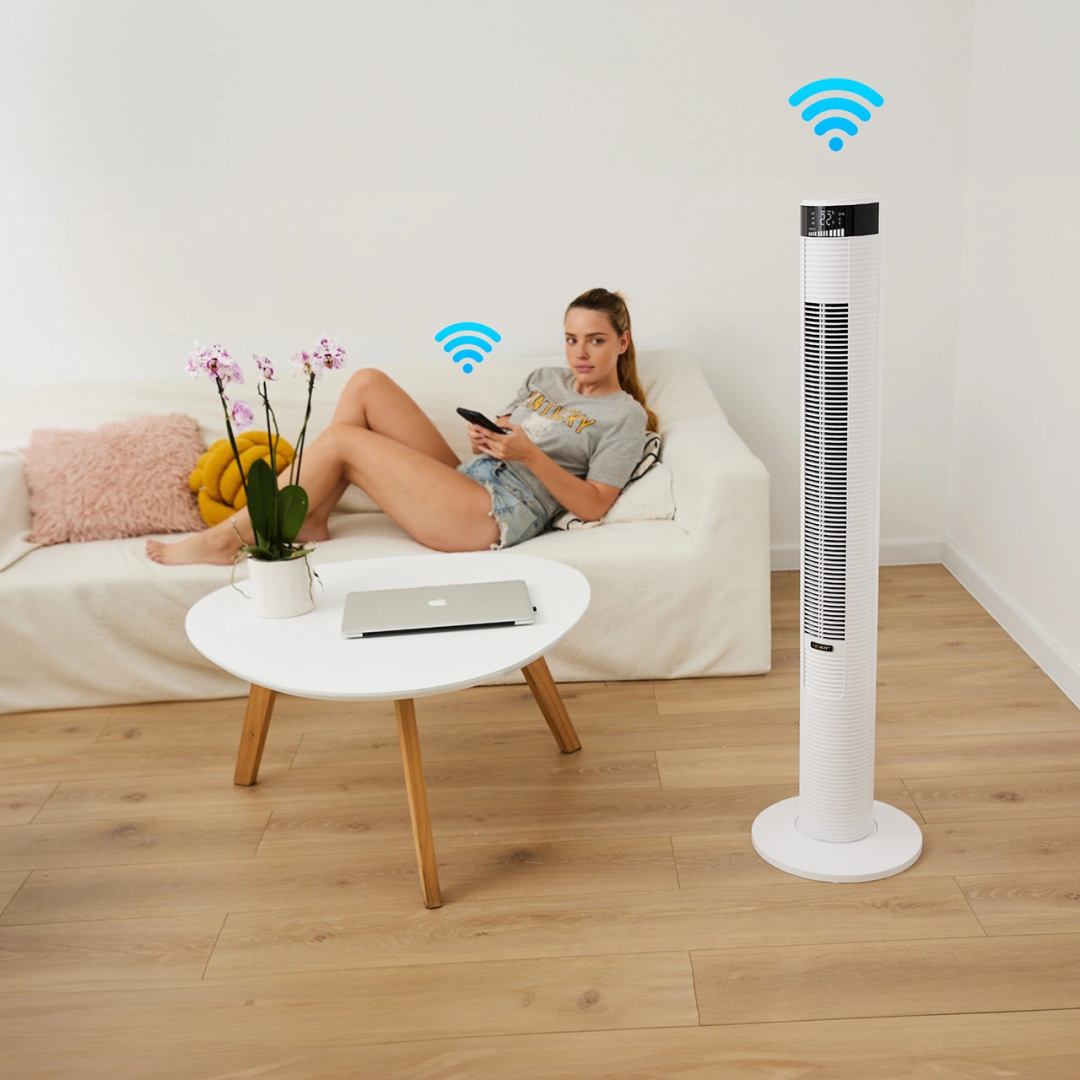 Kobieta siedzi na kanapie z wentylatorem w pobliżu. Trzyma telefon, nad którym znajdują się ikony Wi-Fi.