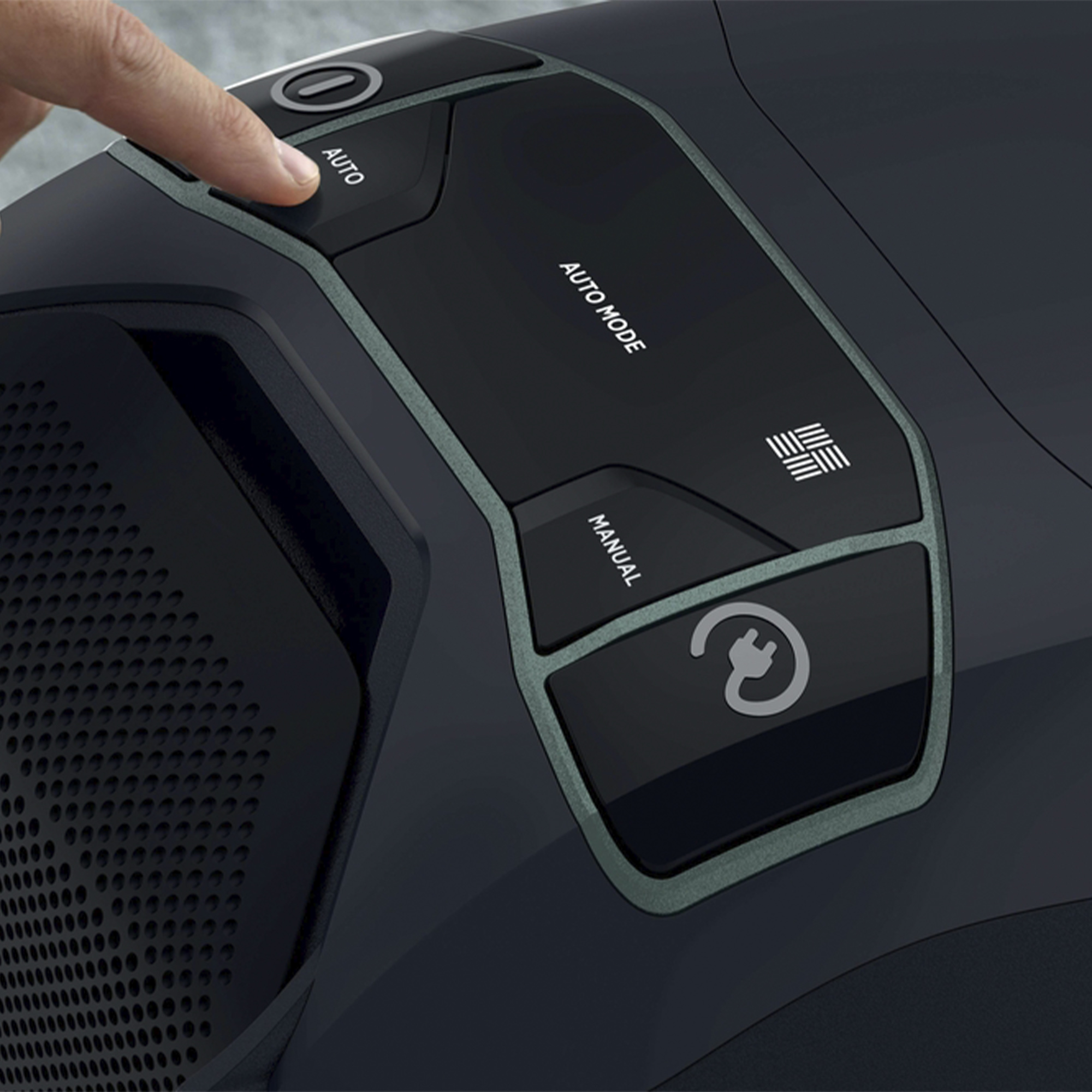 Zbliżenie panelu sterowania odkurzacza. Palec naciska przycisk 'AUTO'. Panel jest czarny.