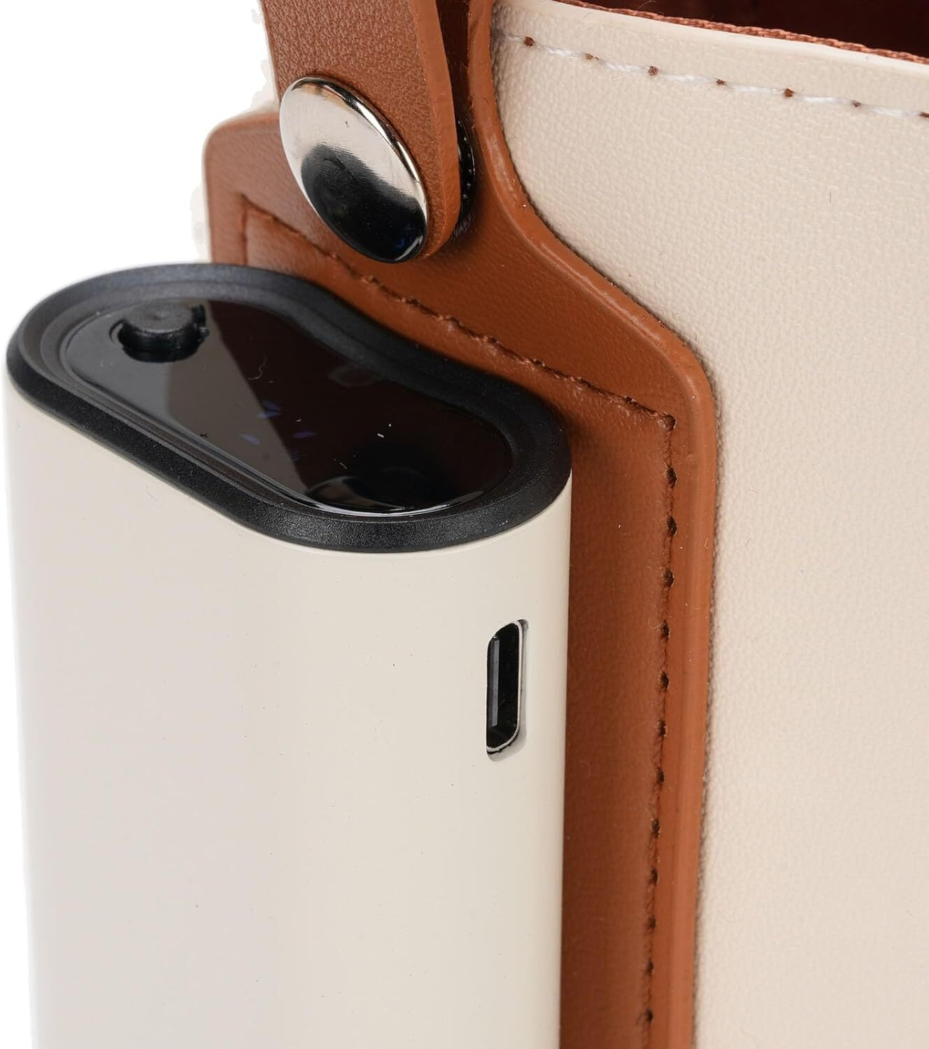 Nahaufnahme einer weißen Powerbank mit einem braunen Riemen, der an einer weiß-braunen Tasche befestigt ist.