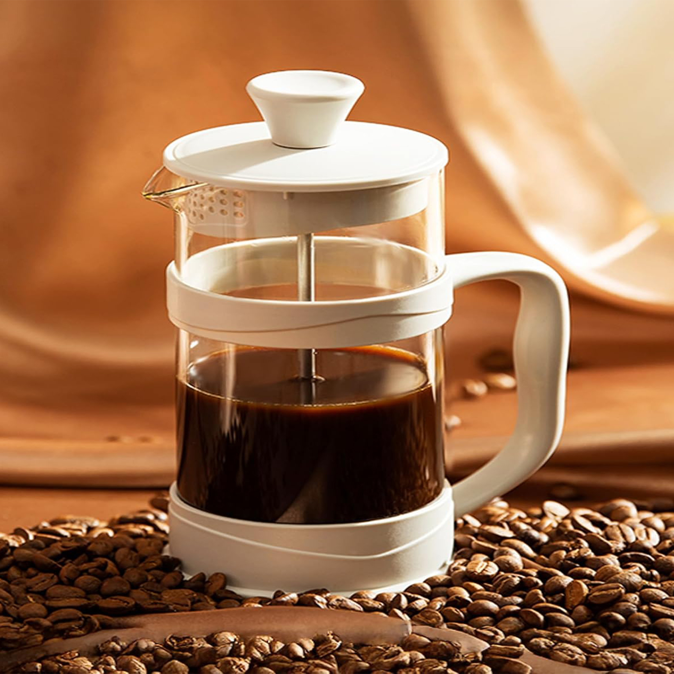 Eine French Press mit Kaffee. Sie steht auf einer Oberfläche mit Kaffeebohnen. Hat einen Holzdeckel und -griff.