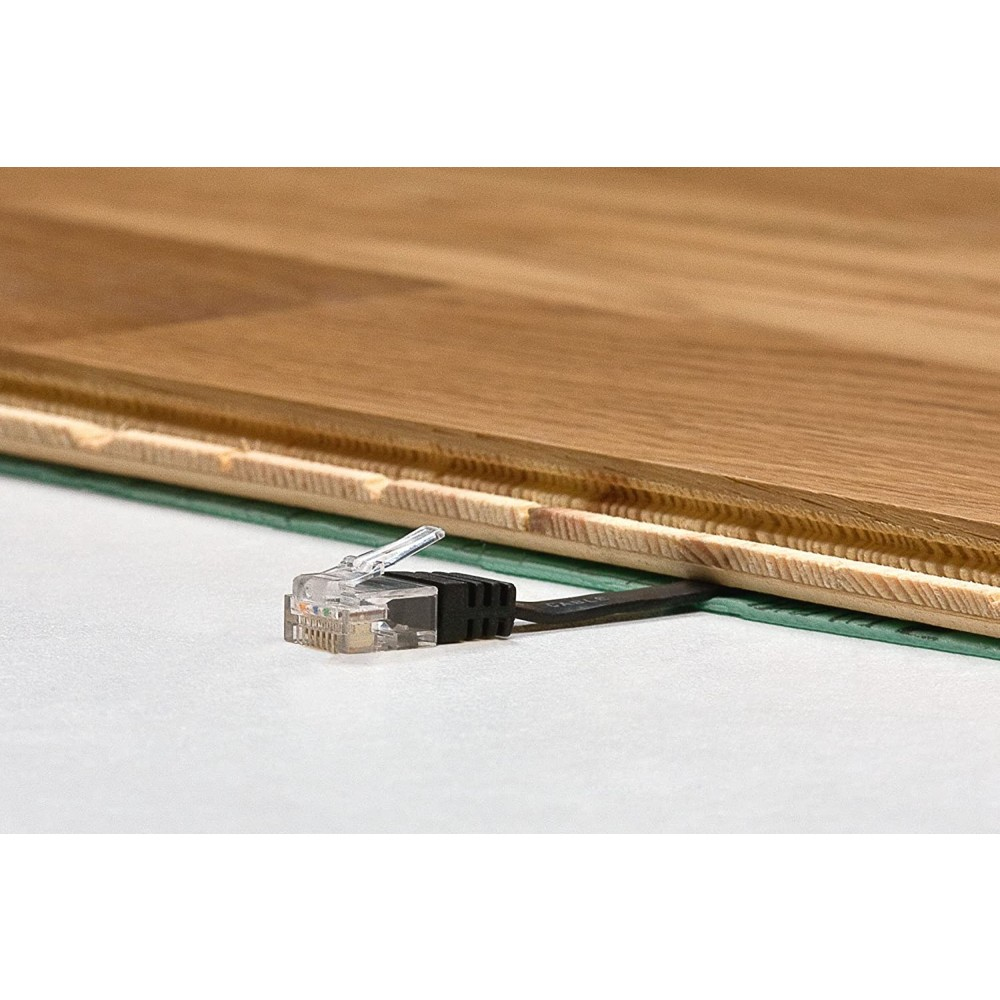 Cavo di rete con connettore trasparente collegato a una superficie in legno, con uno strato verde sottostante.