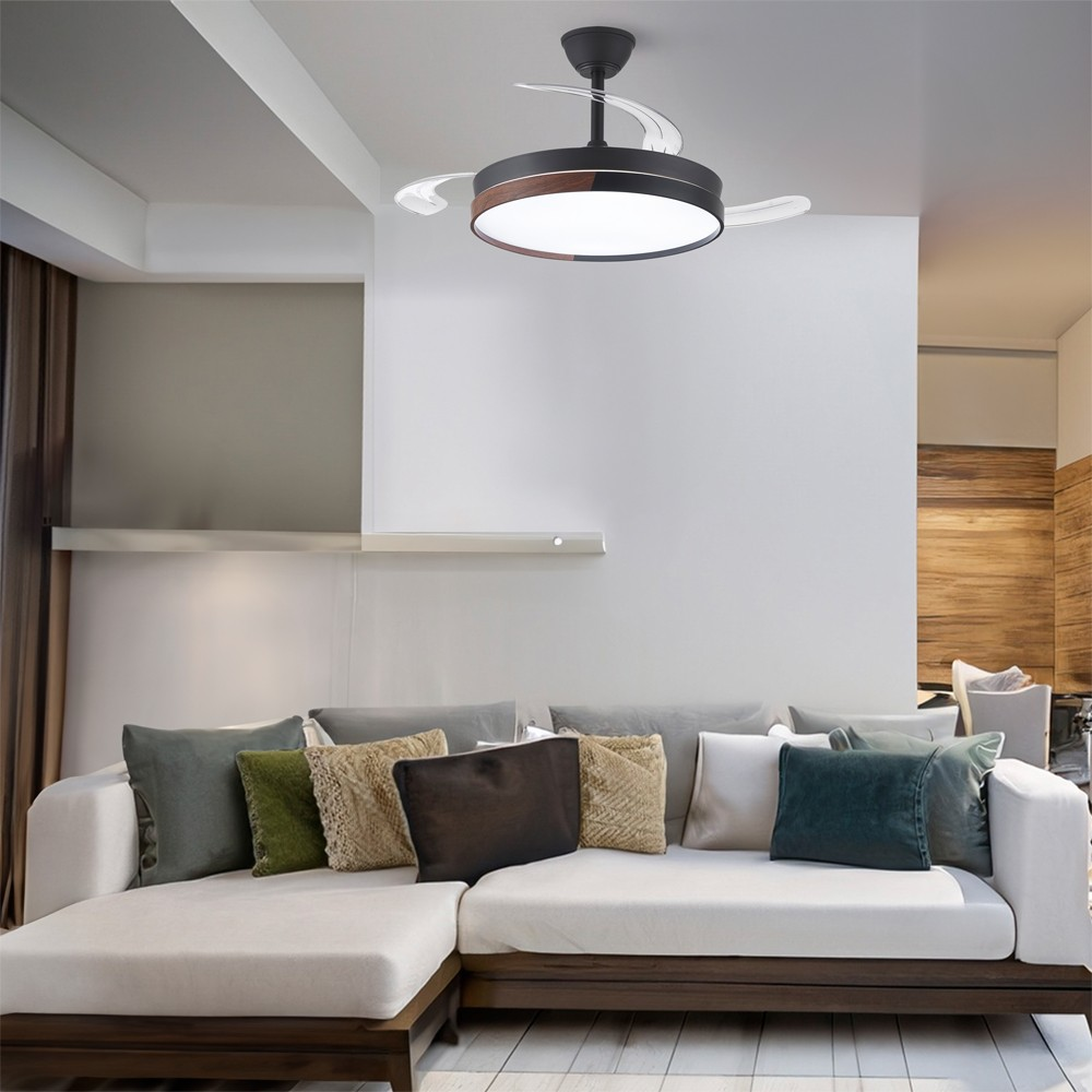 Una sala de estar con un ventilador de techo, un sofá y una pared blanca.
