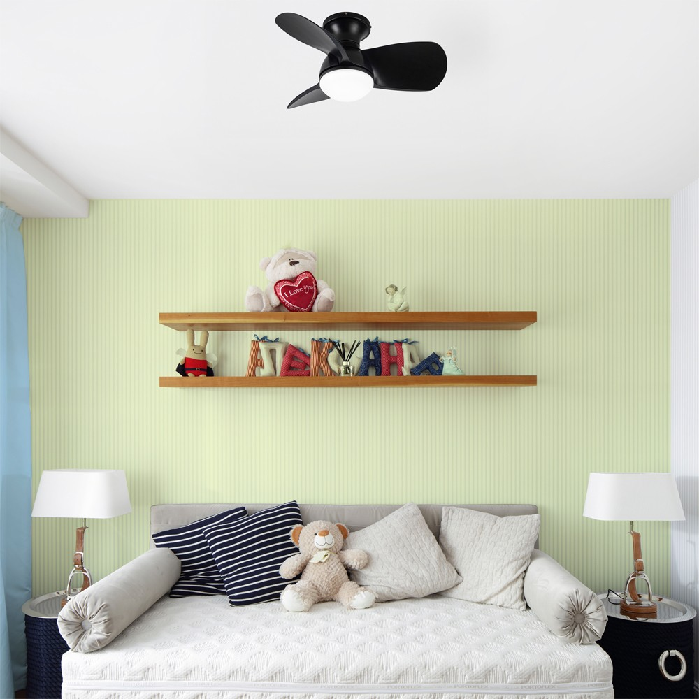 Una habitación con una pared verde claro a rayas. Un ventilador de techo está encima de dos estantes con decoración.