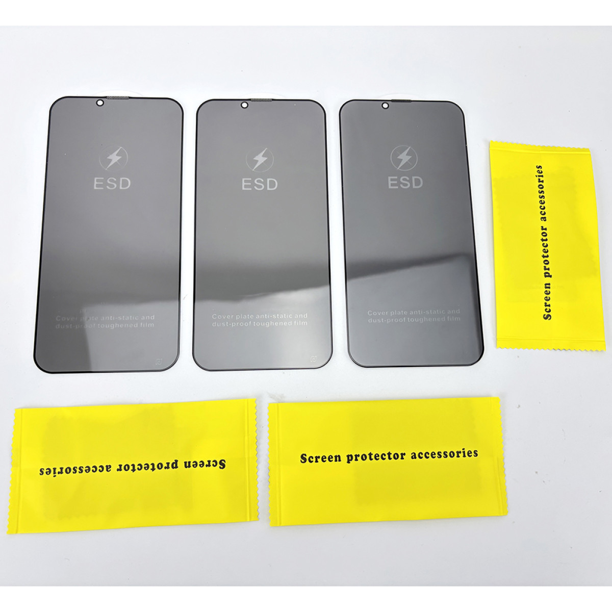 Drie donkere schermbeschermers en drie gele accessoirepakketten. De schermbeschermers hebben het 'ESD'-symbool en bliksemschicht.